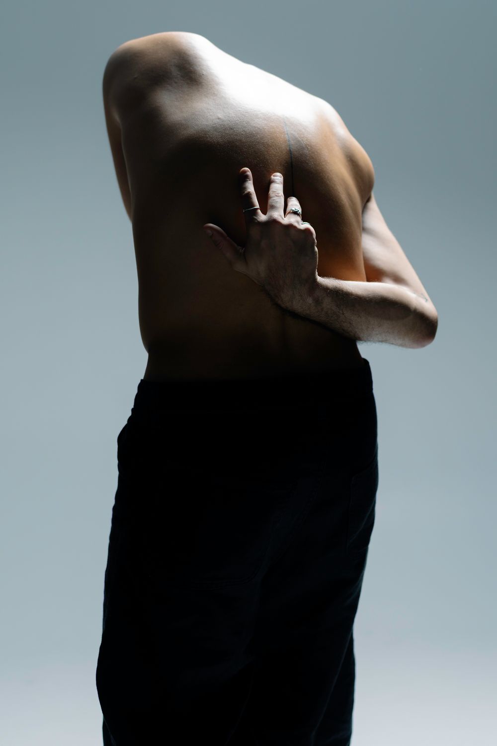 Abstract series of black silhouettes against a muted blue background showing progressive movement and form.