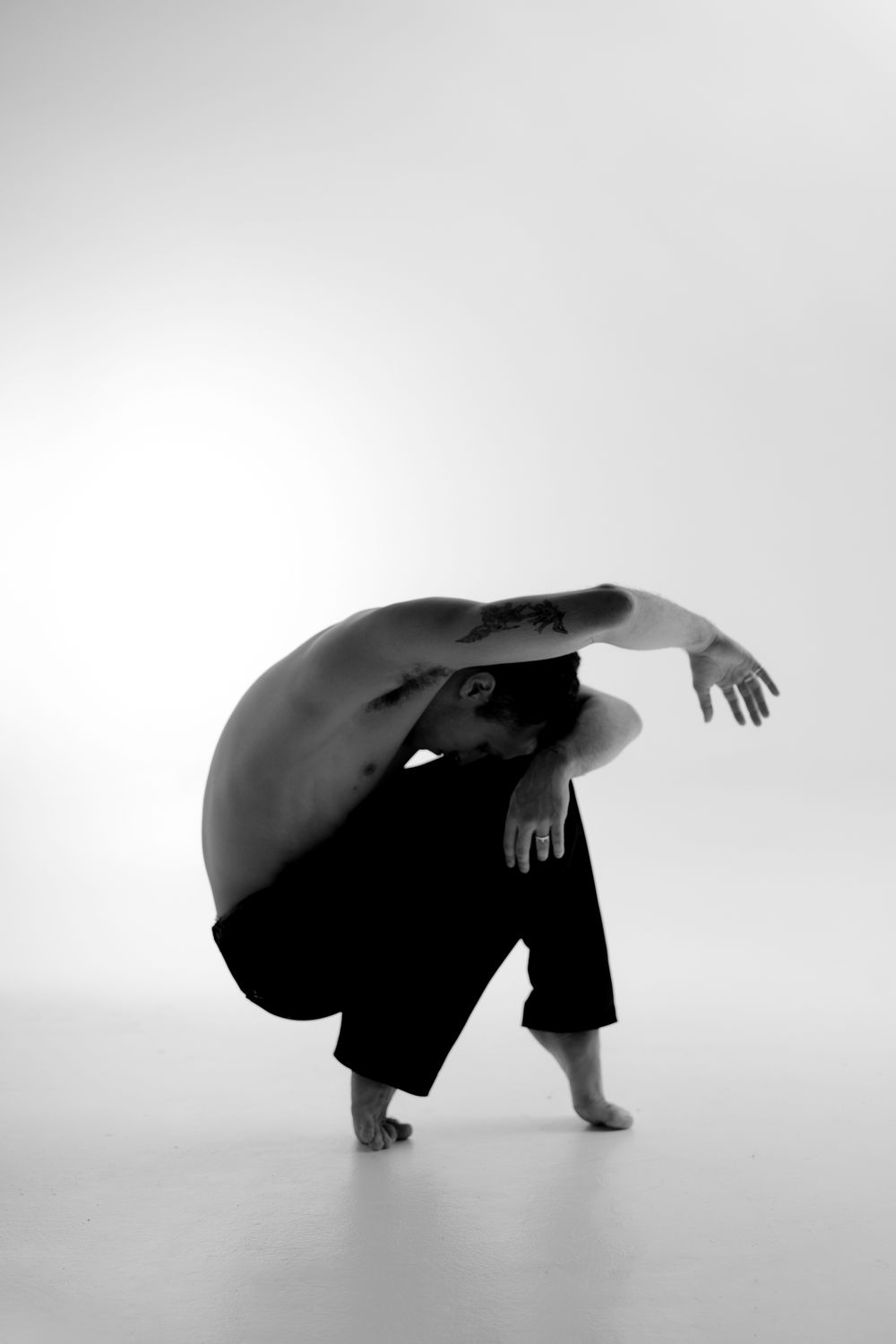A series of silhouetted figures in graceful dance movements shown in a minimalist black and white composition.