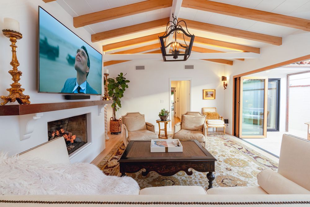 Modern interior design with exposed wooden beams, white walls, and a lantern-style pendant light fixture in a bright room.