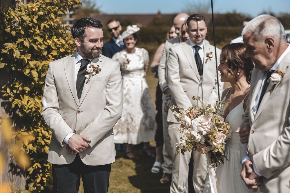 Emotional candid moment of groom seeing his bride during the wedding ceremony.
