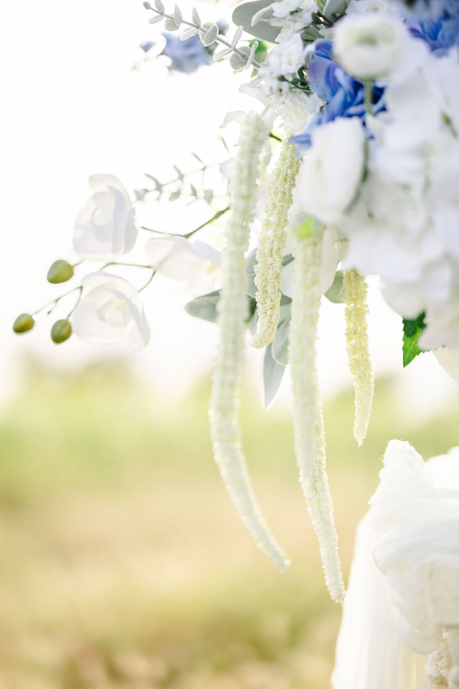Elegant white and blue floral arrangements with cascading elements against a soft background.