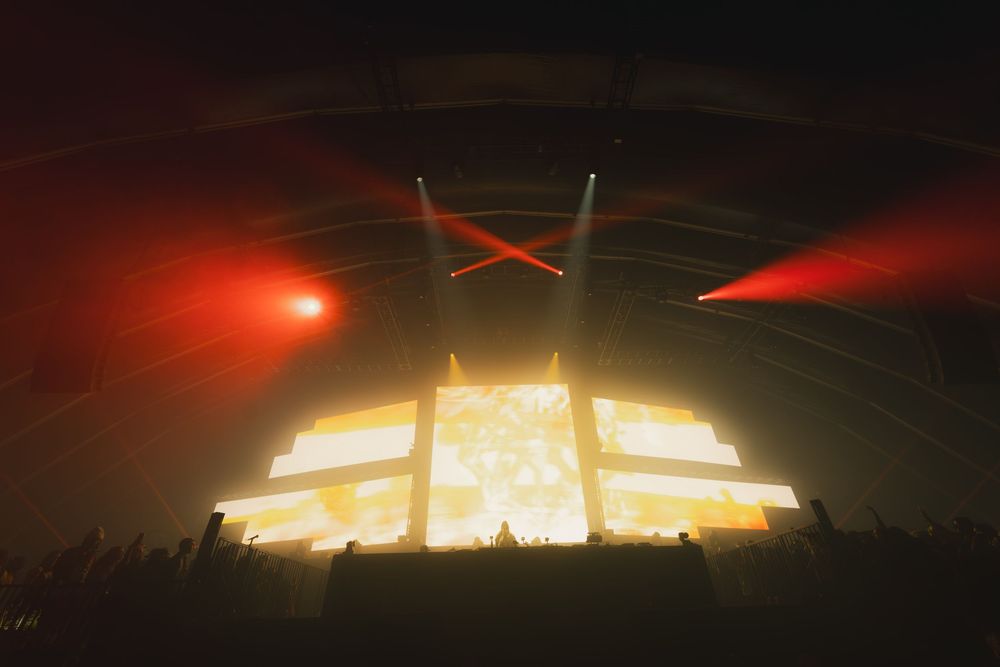 Concert stage illuminated with red and orange lighting effects creating an angular architectural display.