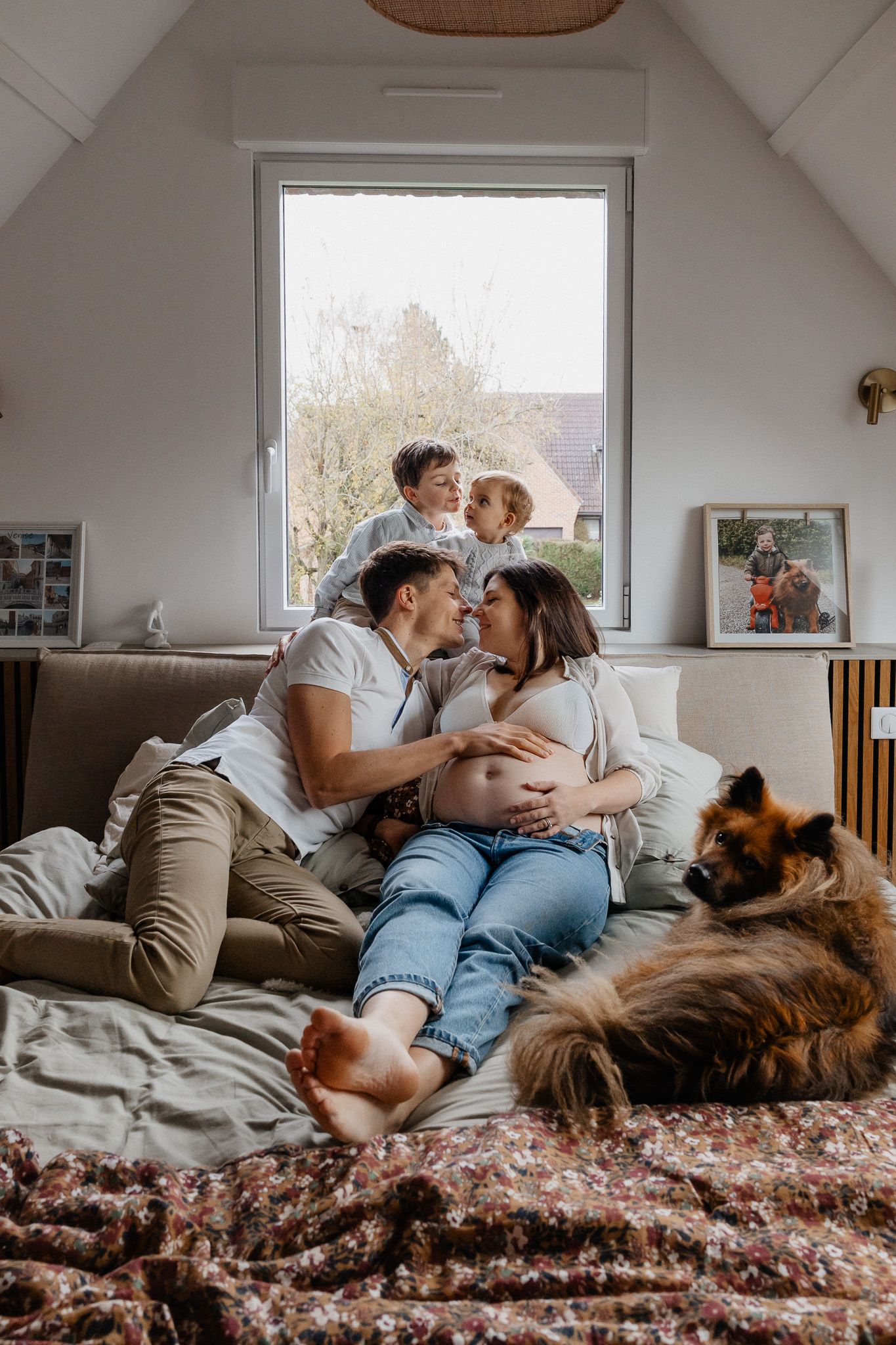 Calins du matin sur le lit familial lors d’une séance grossesse en famille Lille douce et vraie.