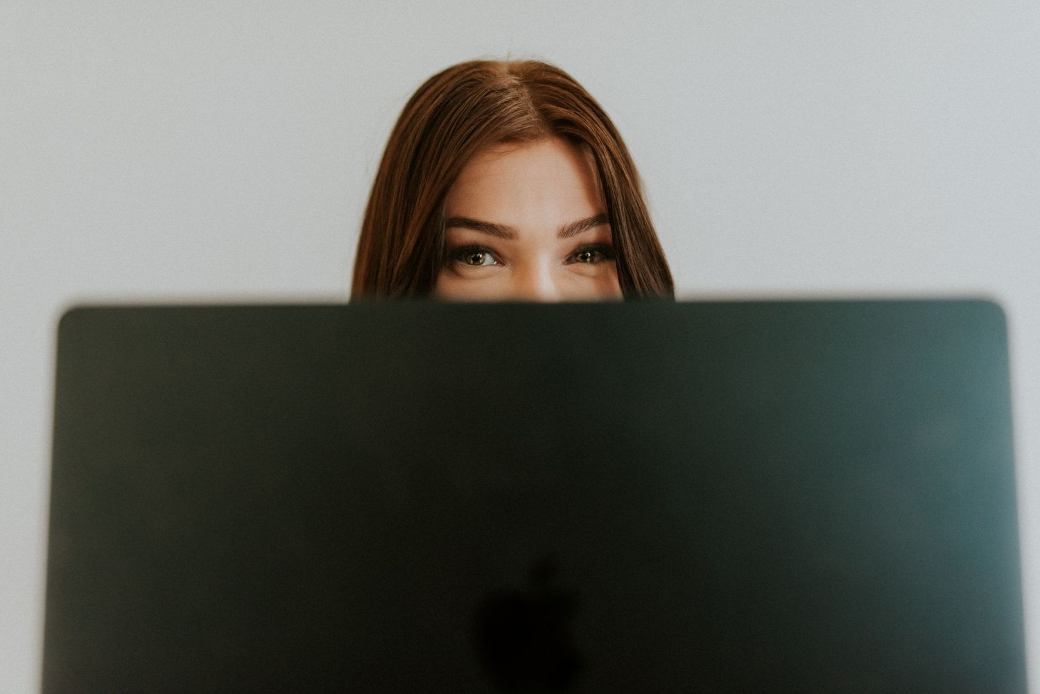 Branding photo for a photographer in studio on her laptop where only her eyes are visible to the camera in Clarksville, Tennessee.