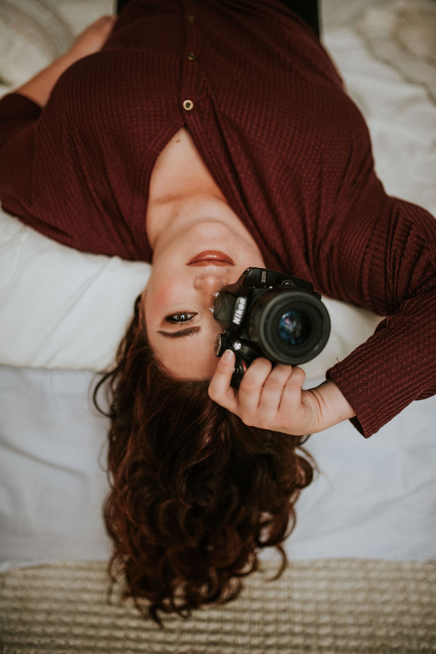 Branding photo of a photographer laying on a bed with her hair behind her in a Studio in Clarksville, Tennessee.