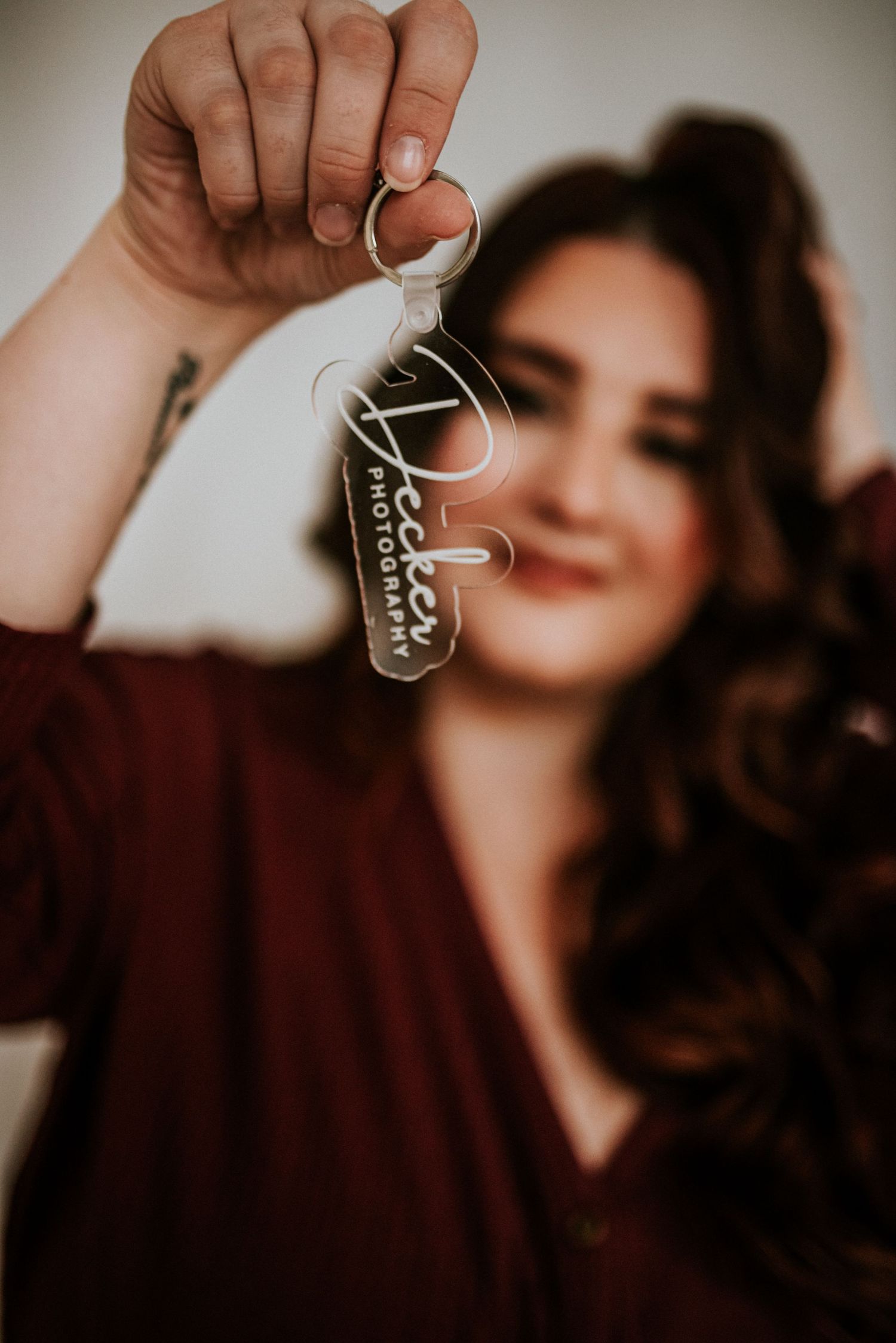 Branding photo of a photographer holding a keychain with her photography business logo on it in studio in Clarksville, Tennessee.