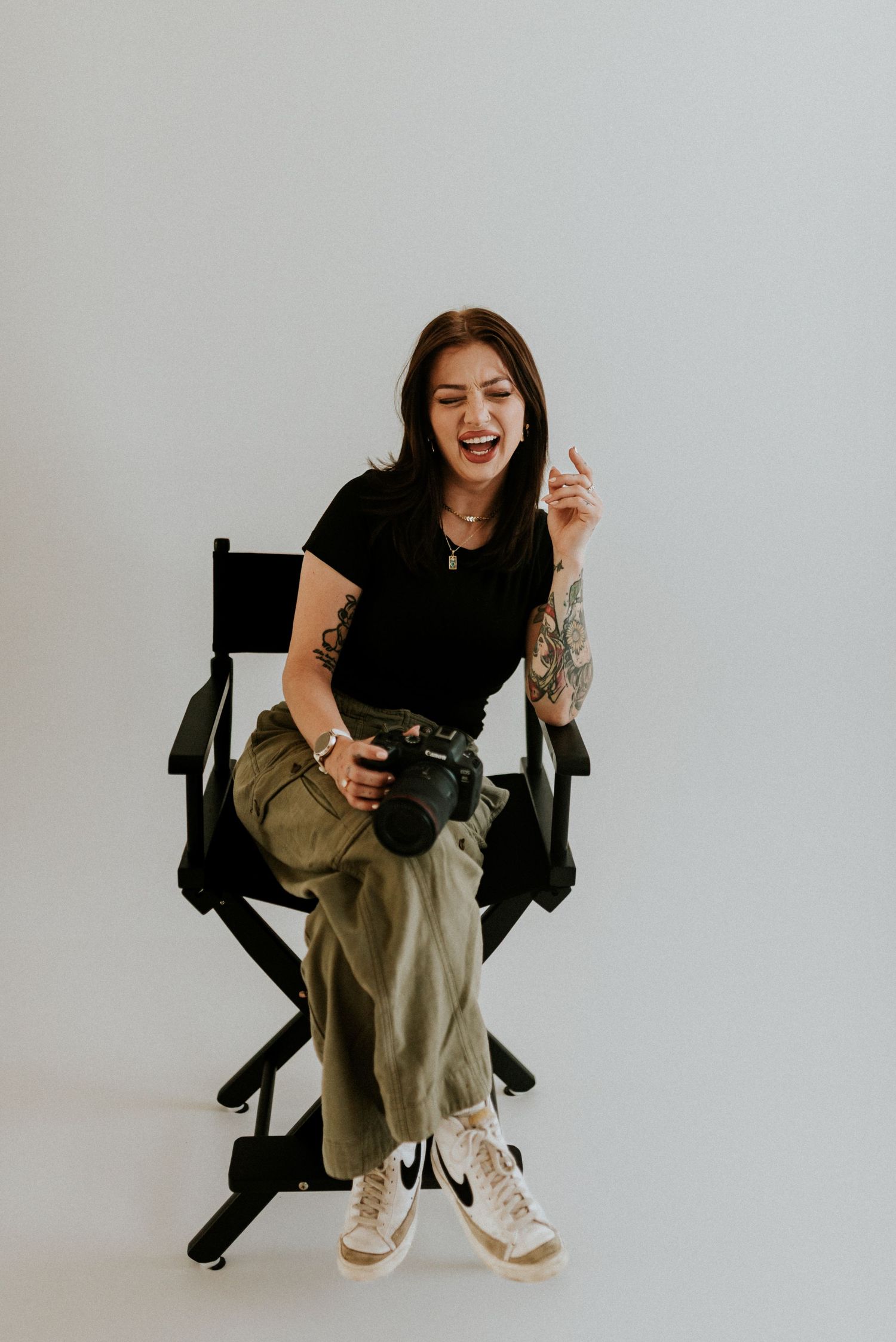 Branding photo of a photographer laughing sitting in the director's chair in the studio in Clarksville, Tennessee.