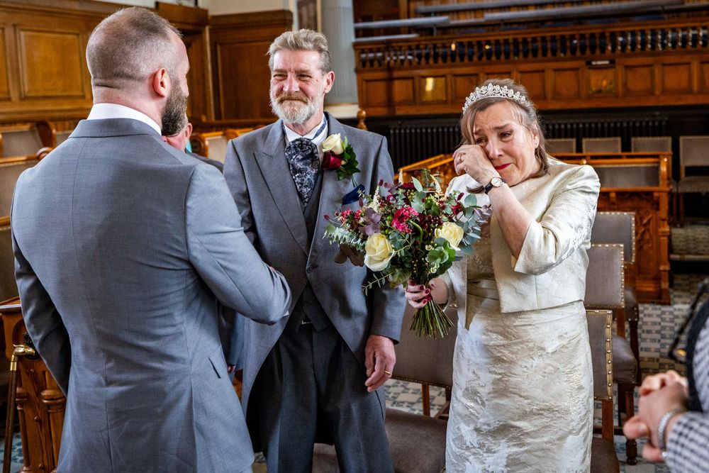 Dorothy and John stand together during their wedding ceremony at Southport Town Hall, with Dorothy wiping away tears in an emotional moment