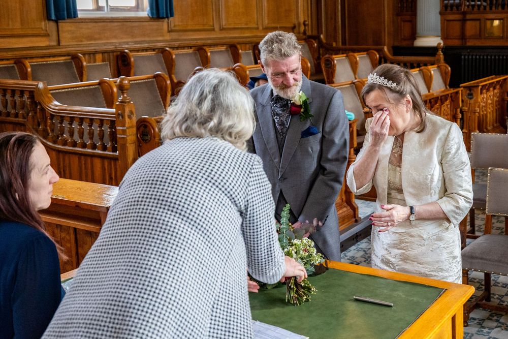 Registrar speaks to Dorothy and John during their intimate Southport Town Hall wedding ceremony as Dorothy wipes away tears.