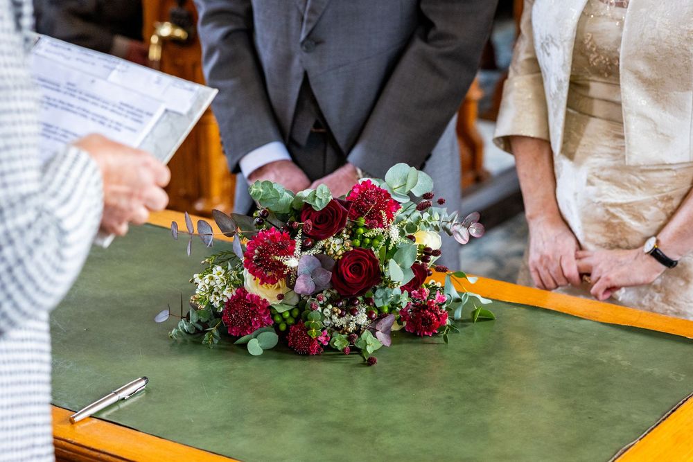 Wedding bouquet on the registrar’s desk at Southport Town Hall during Dorothy and John’s small family wedding ceremony.