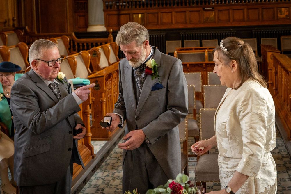 Groom prepares the wedding rings as the bride watches during their intimate ceremony inside Southport Town Hall.