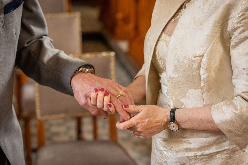Close-up of bride placing wedding ring on groom’s finger during their intimate Southport Town Hall ceremony.