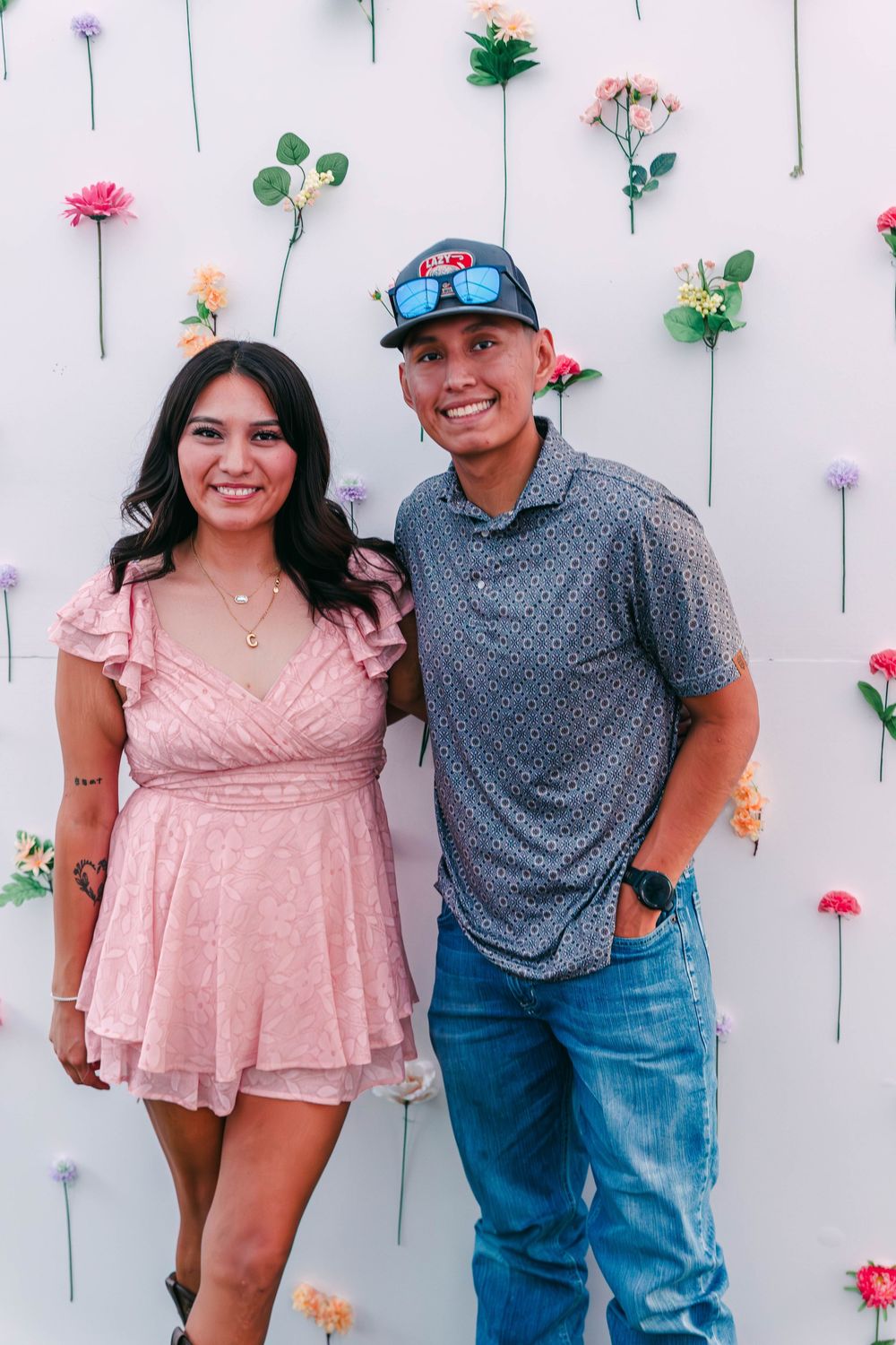 A floral wall backdrop creates a romantic photo setting at an event.