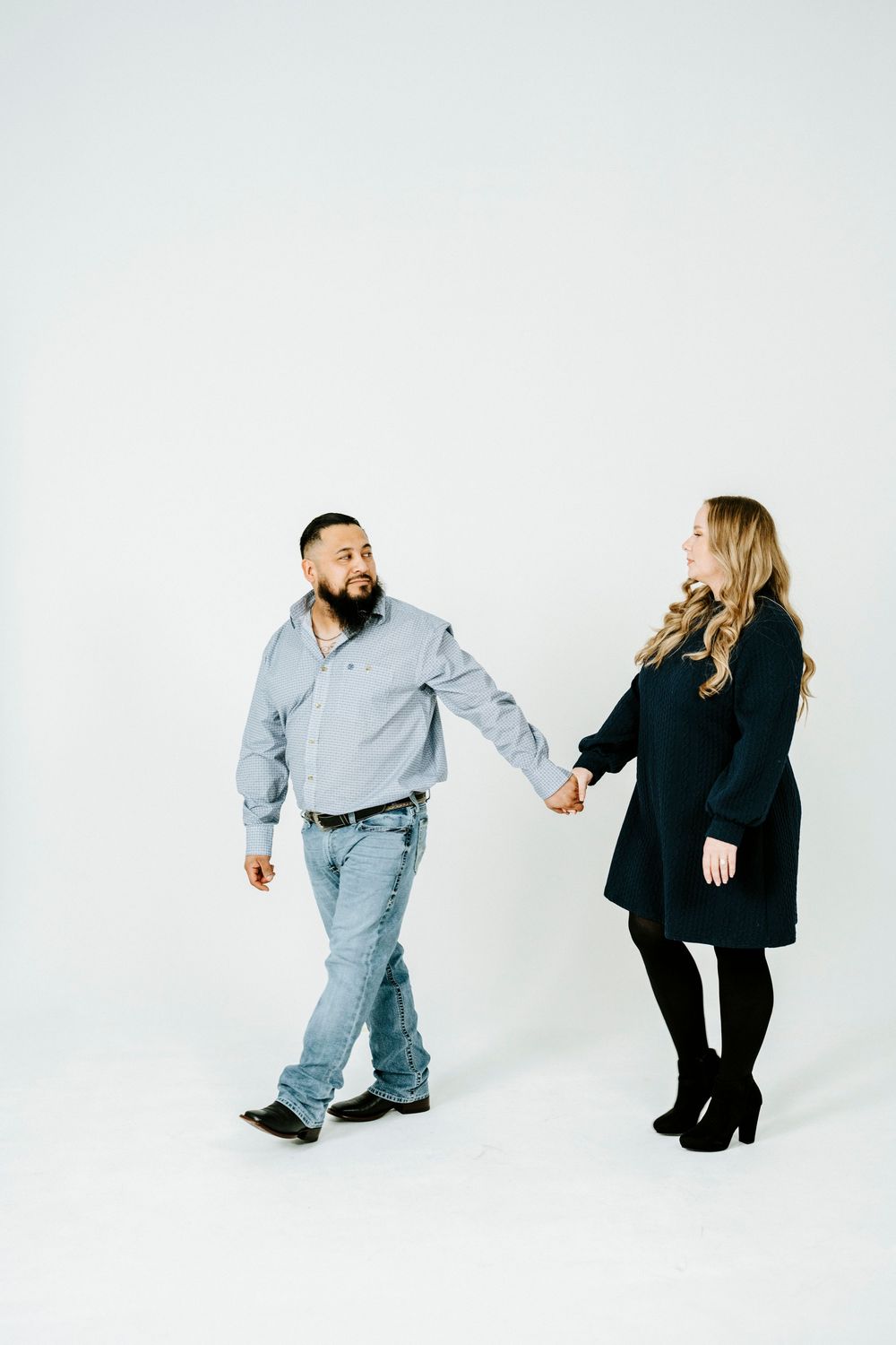 Two people in contrasting outfits interact playfully against a white background in a sequence of candid poses.