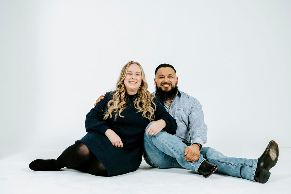 A couple poses together in a series of casual studio portraits against a white background.