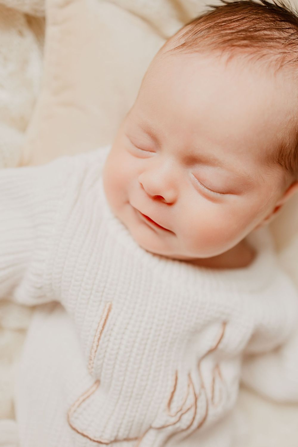 Close up of sleeping newborn baby girl resting on a soft blanket.