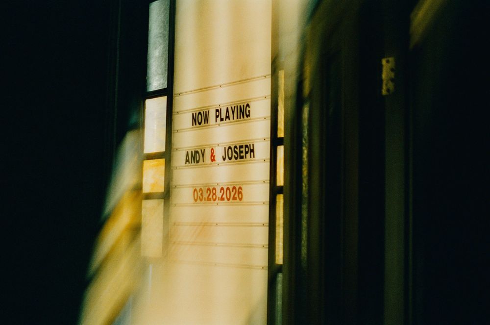 Vintage marquee sign reading Now Playing Andy & Joseph with date 08.22.2026 in warm golden light.