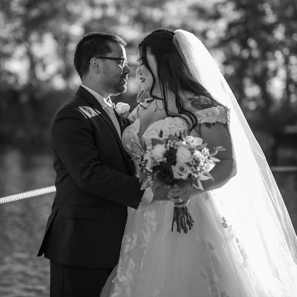 Romantic wedding moment captured in black and white against outdoor background.