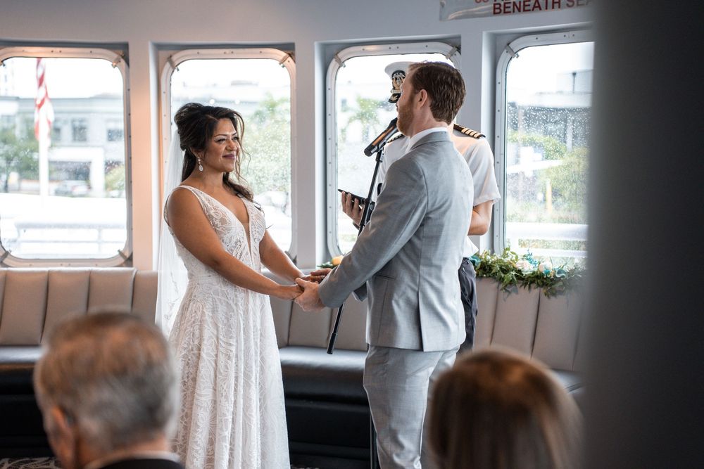 A bride and groom share their first look moment in a window-lit room during their wedding day. Micro wedding on Yacht StarShip in Tampa