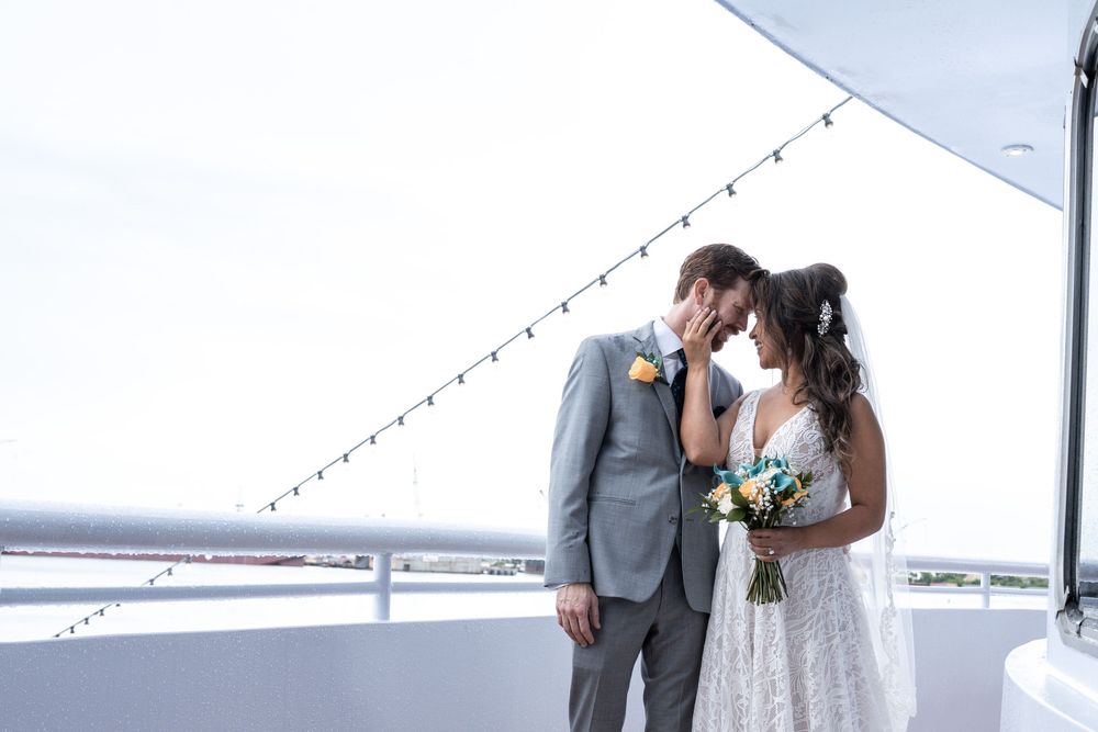 A couple shares a romantic dance at an elegant wedding reception with string lights overhead.