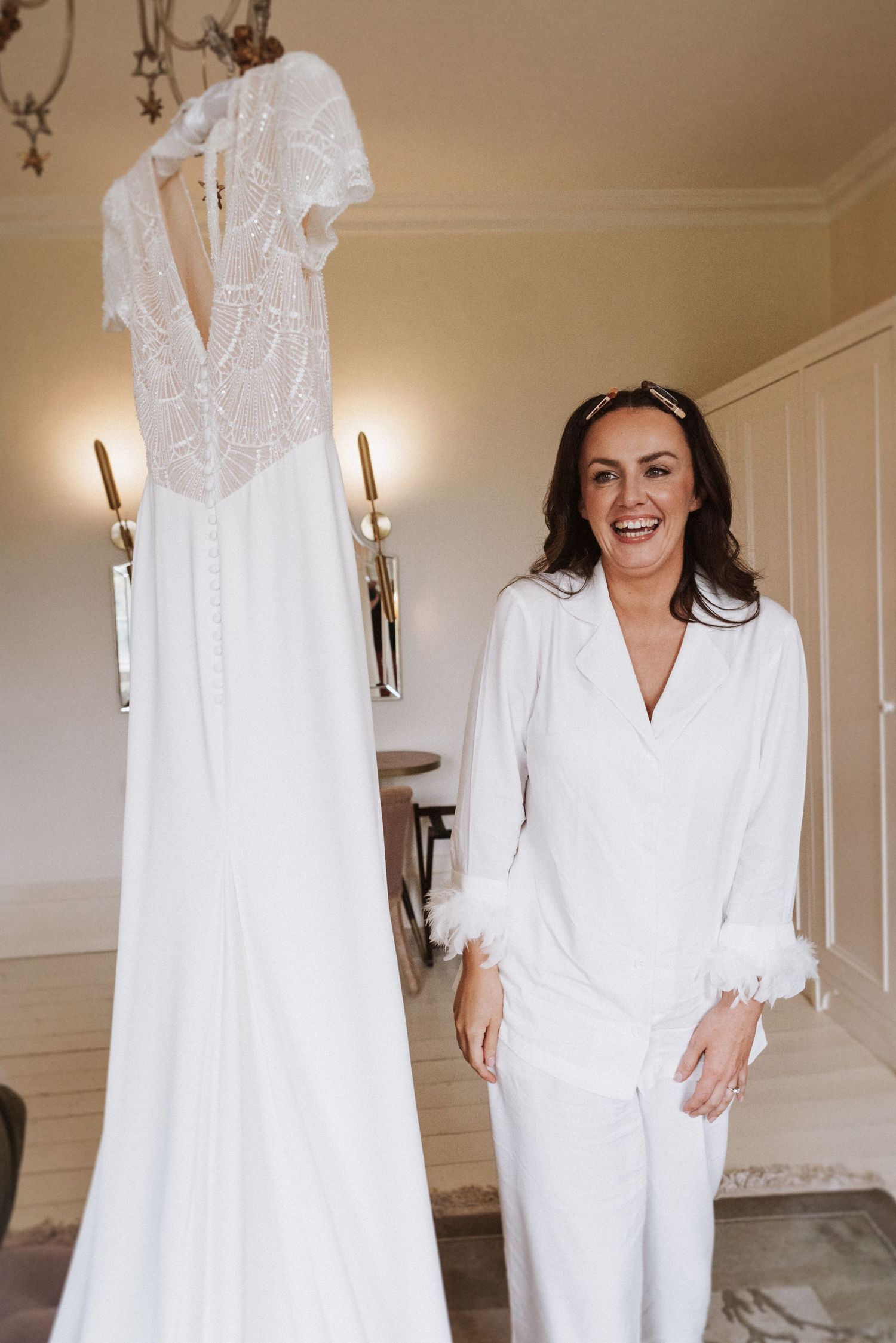 A series of photos showing a white bridal robe against a neutral wall with wall sconces.