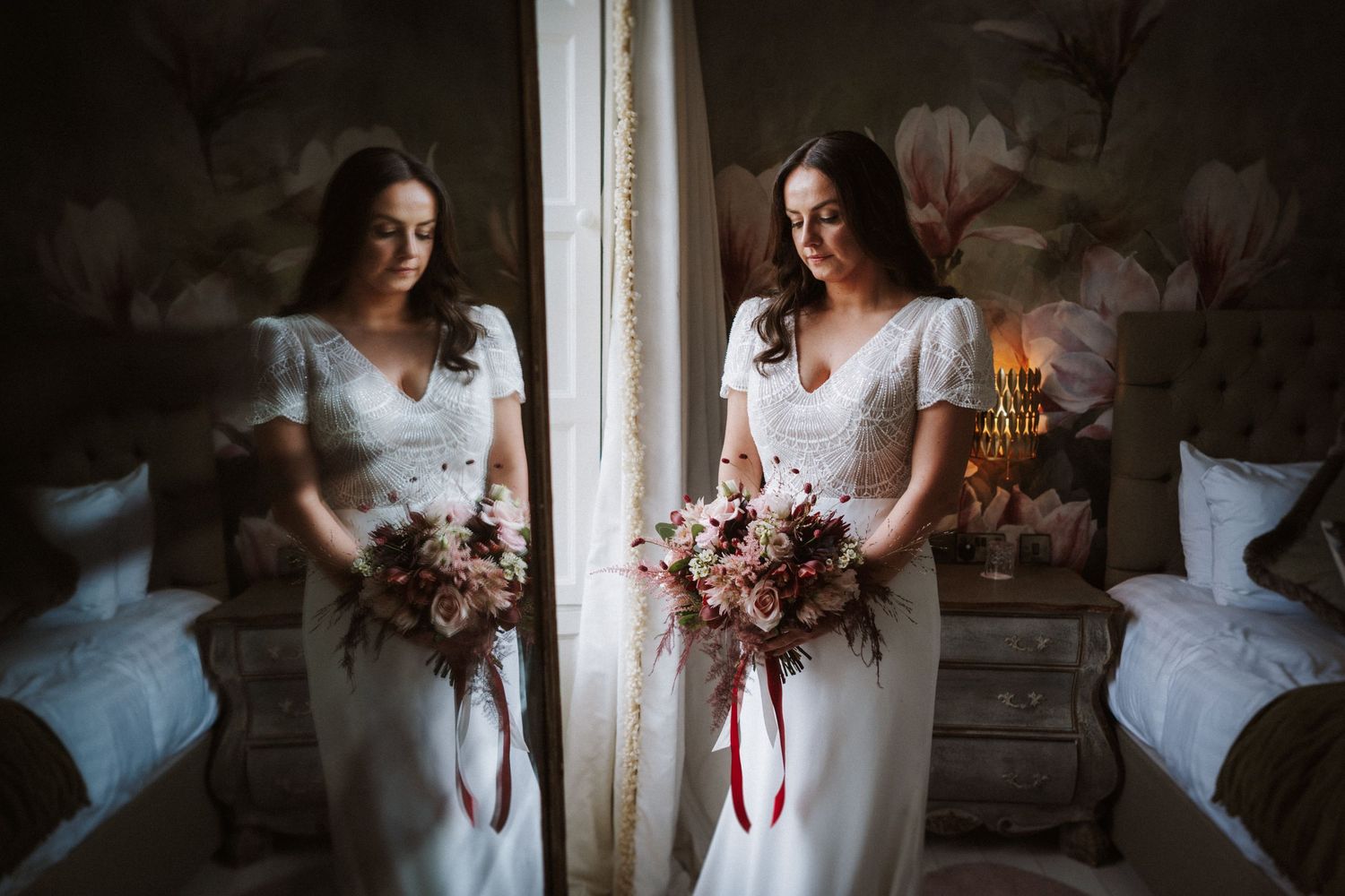 Soft natural light illuminates a romantic bridal portrait session by a window with delicate pink florals.