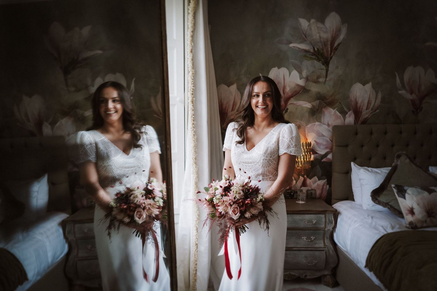 Moody window light creates dramatic shadows in an intimate bridal portrait with pink bouquet details.