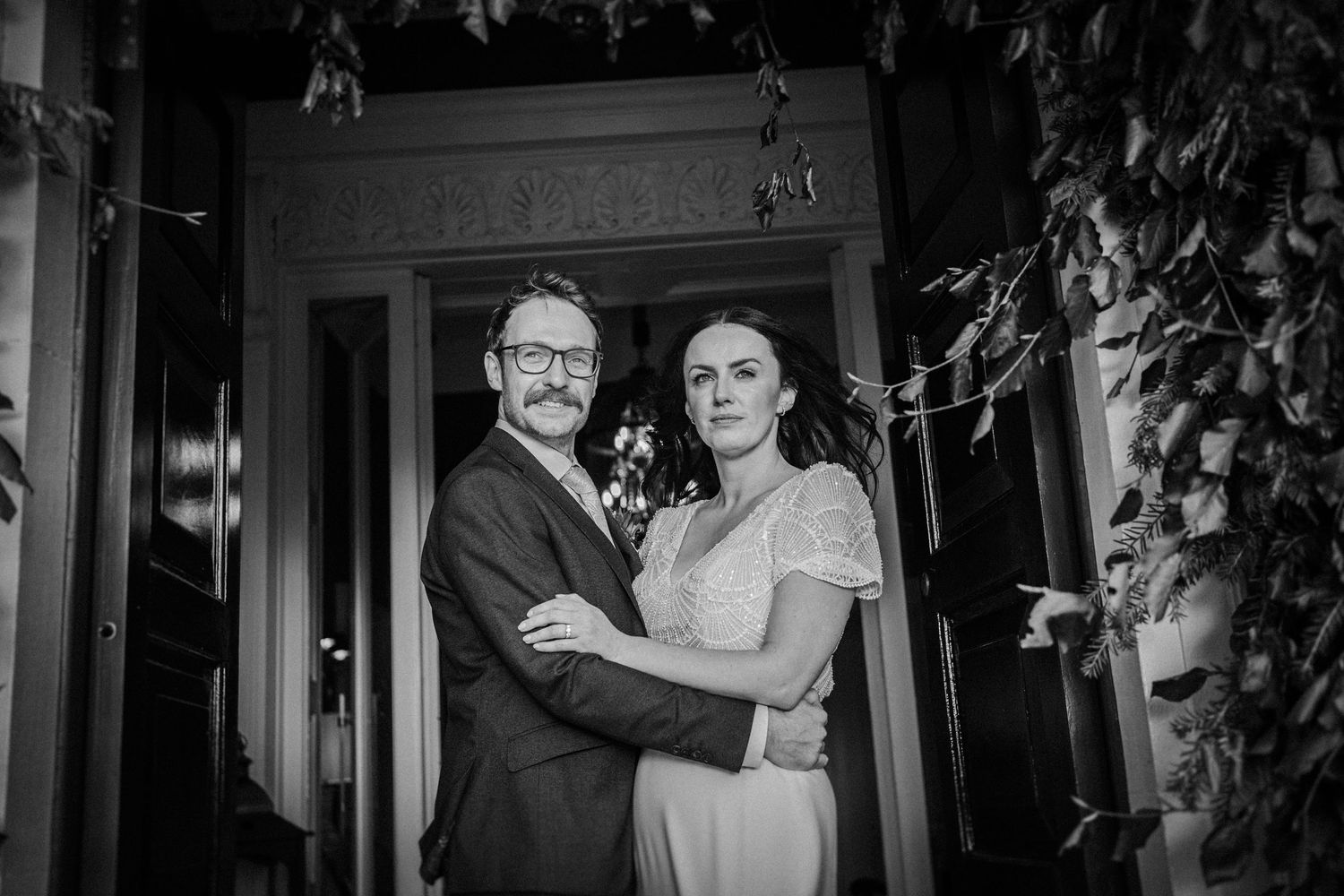 A couple shares their first dance at an elegant wedding reception in a dimly lit venue.
