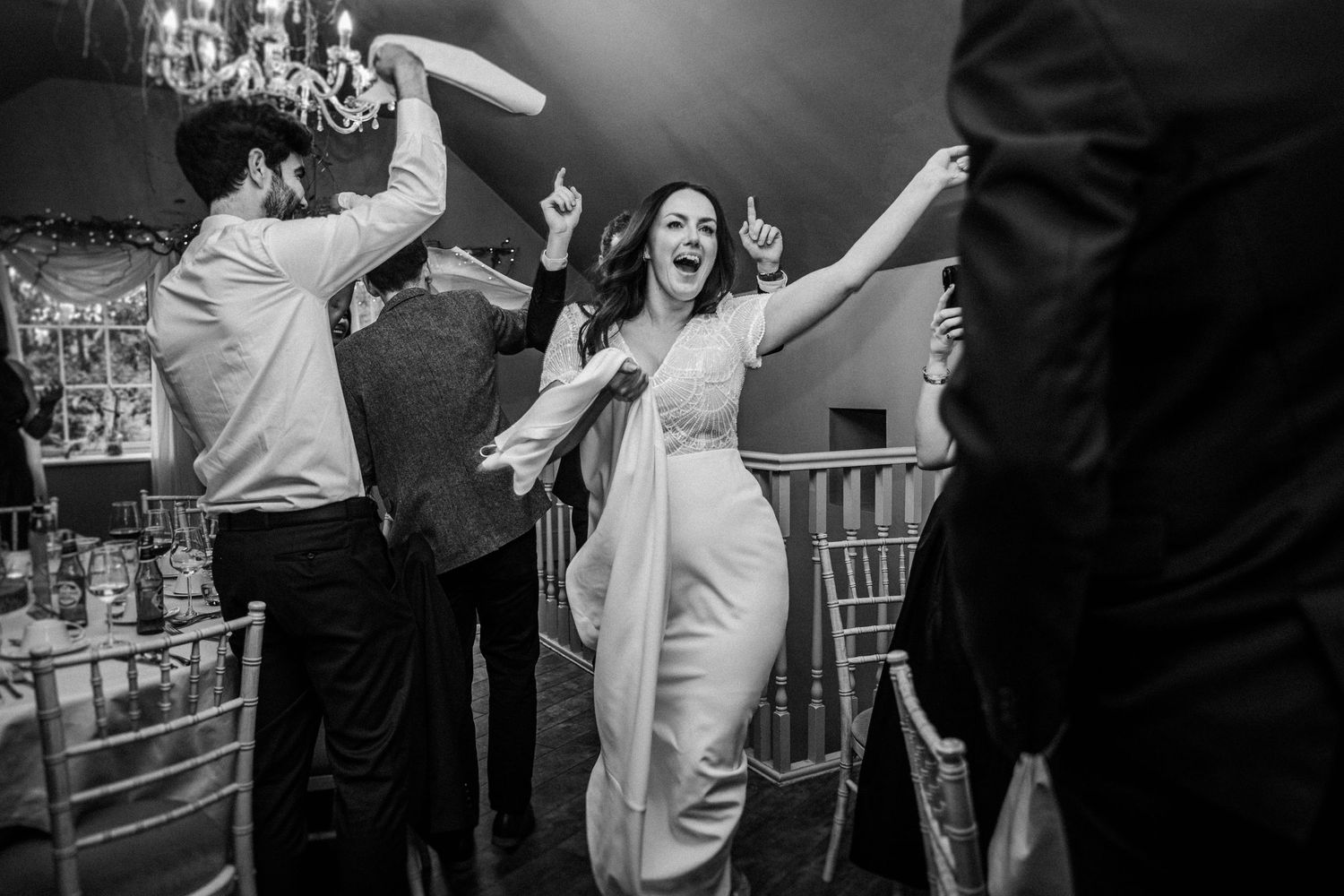 Black and white photo sequence showing dancers performing energetic swing dance moves on a dance floor.