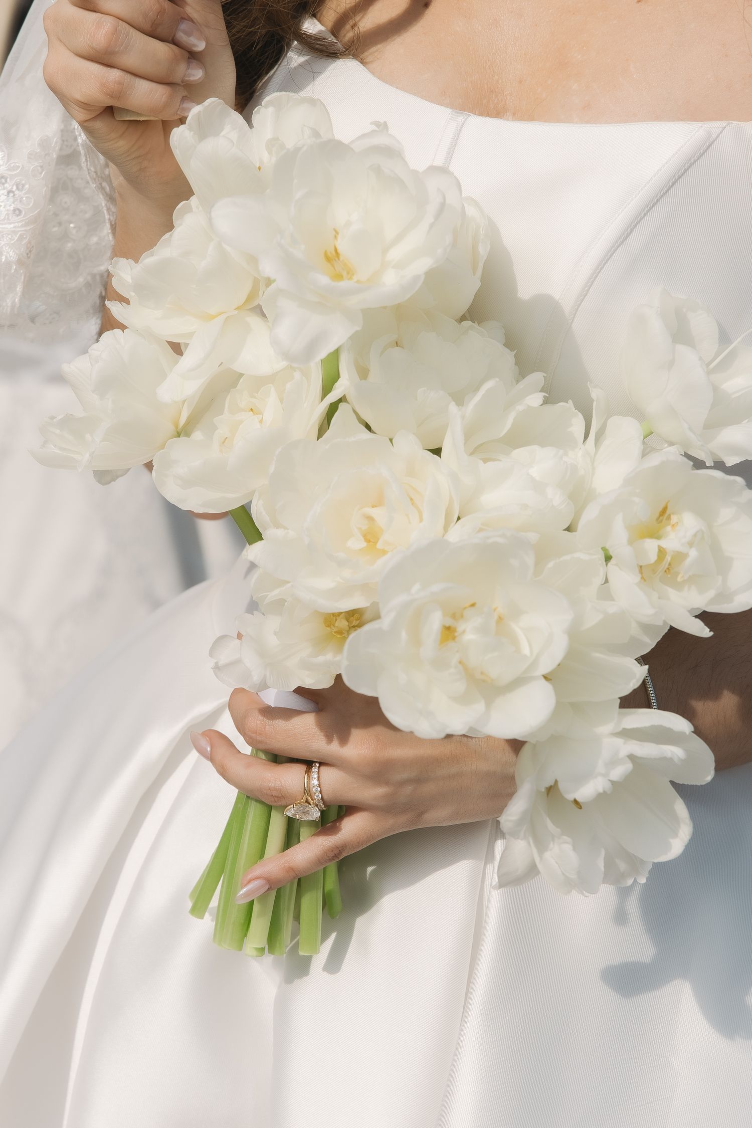 A close-up view of elegant white peony bouquets being held against a white background.