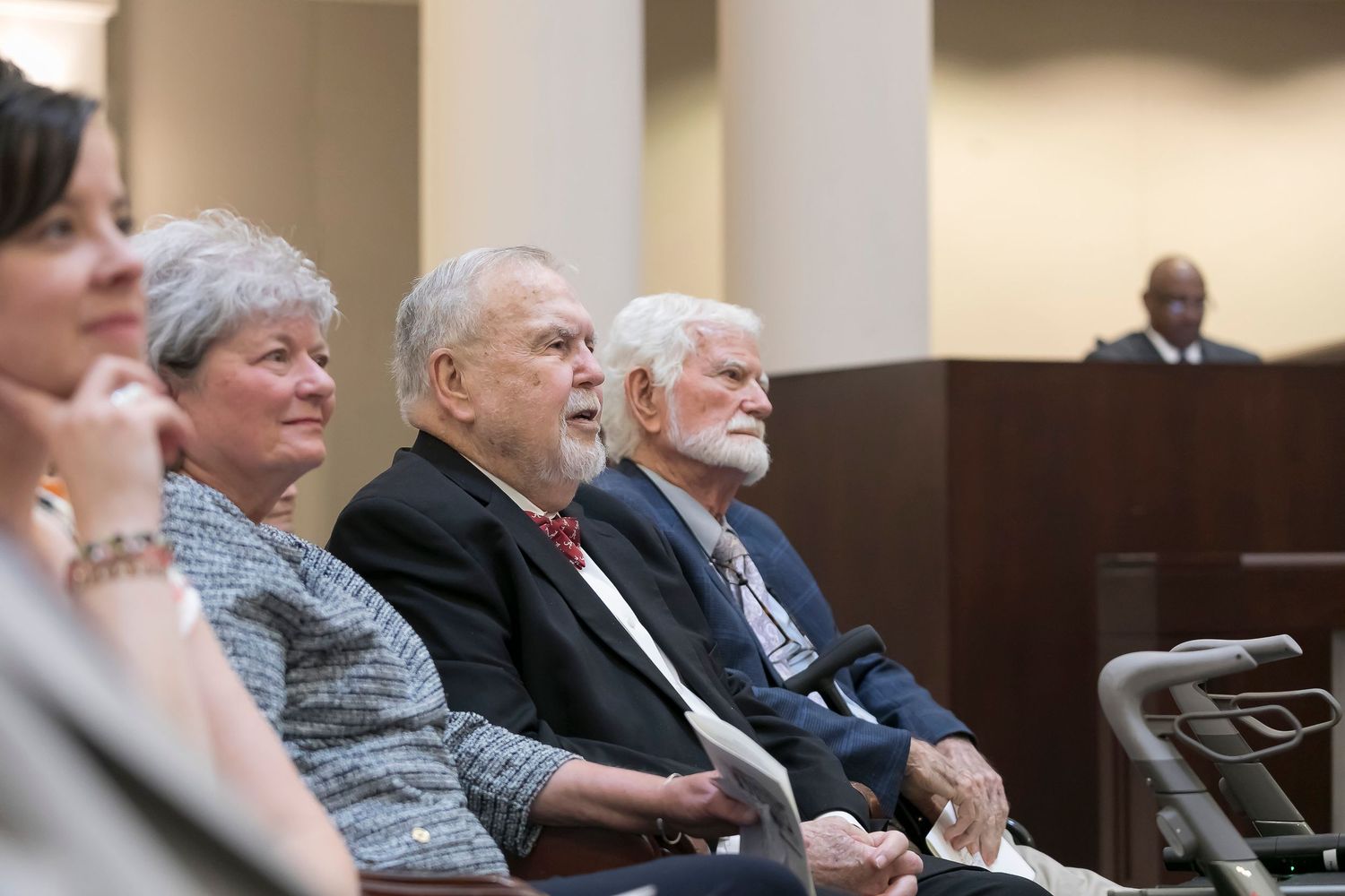 Audience members sit attentively in rows during an indoor presentation or lecture.