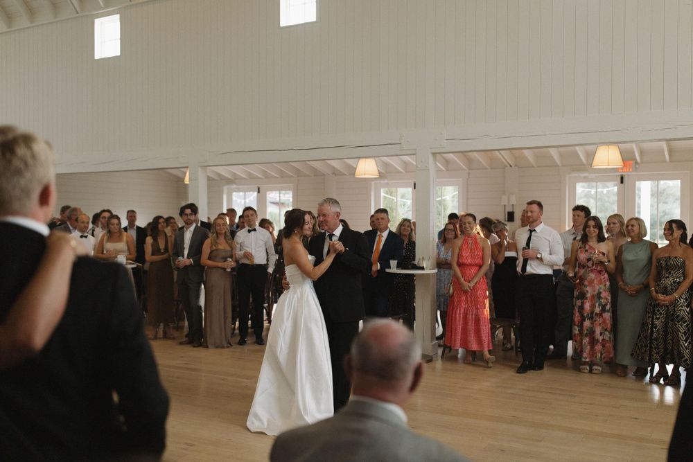 Wedding celebration with guests mingling in a bright chapel setting.