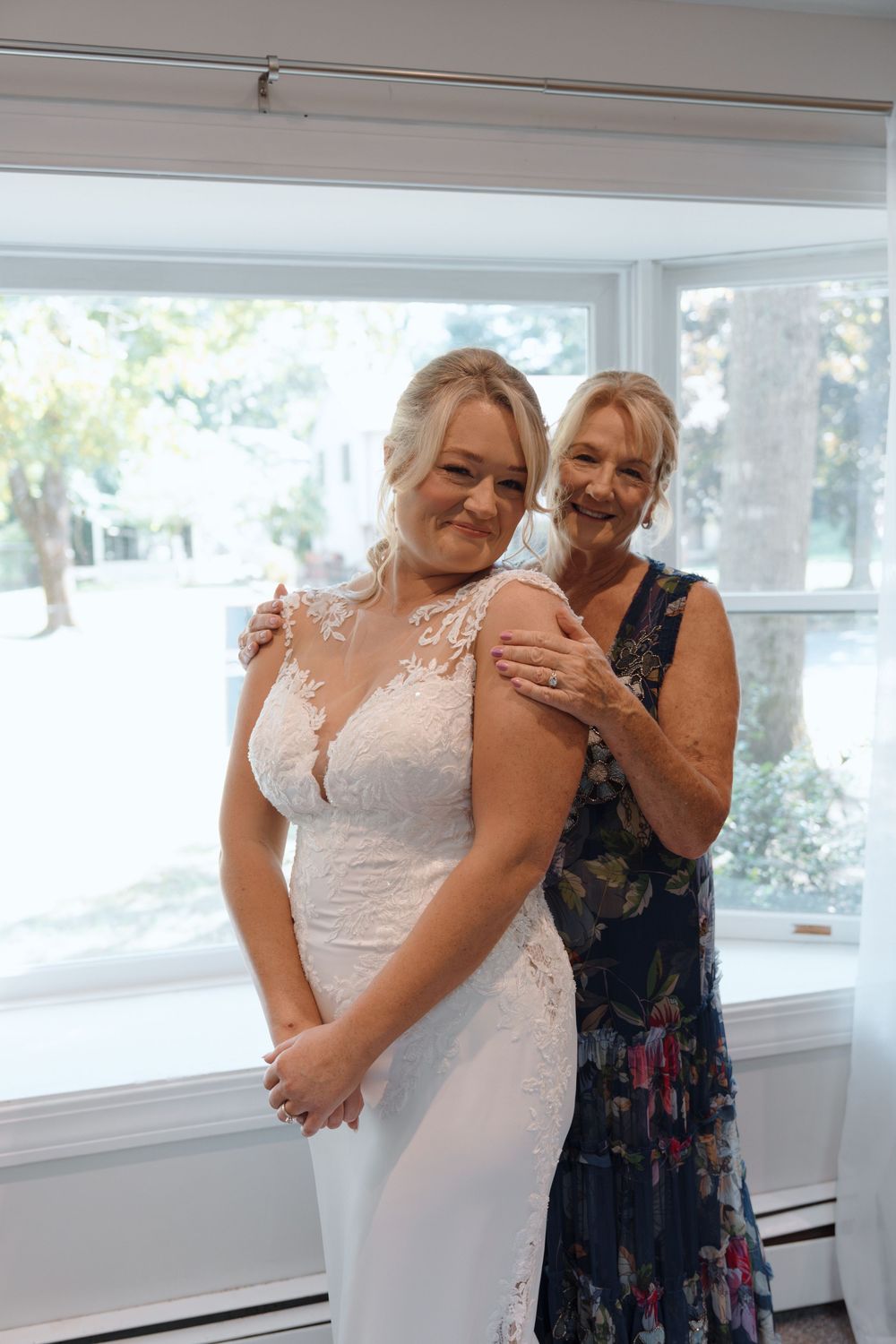 Wedding celebration moment captured in a bright indoor setting with large windows.