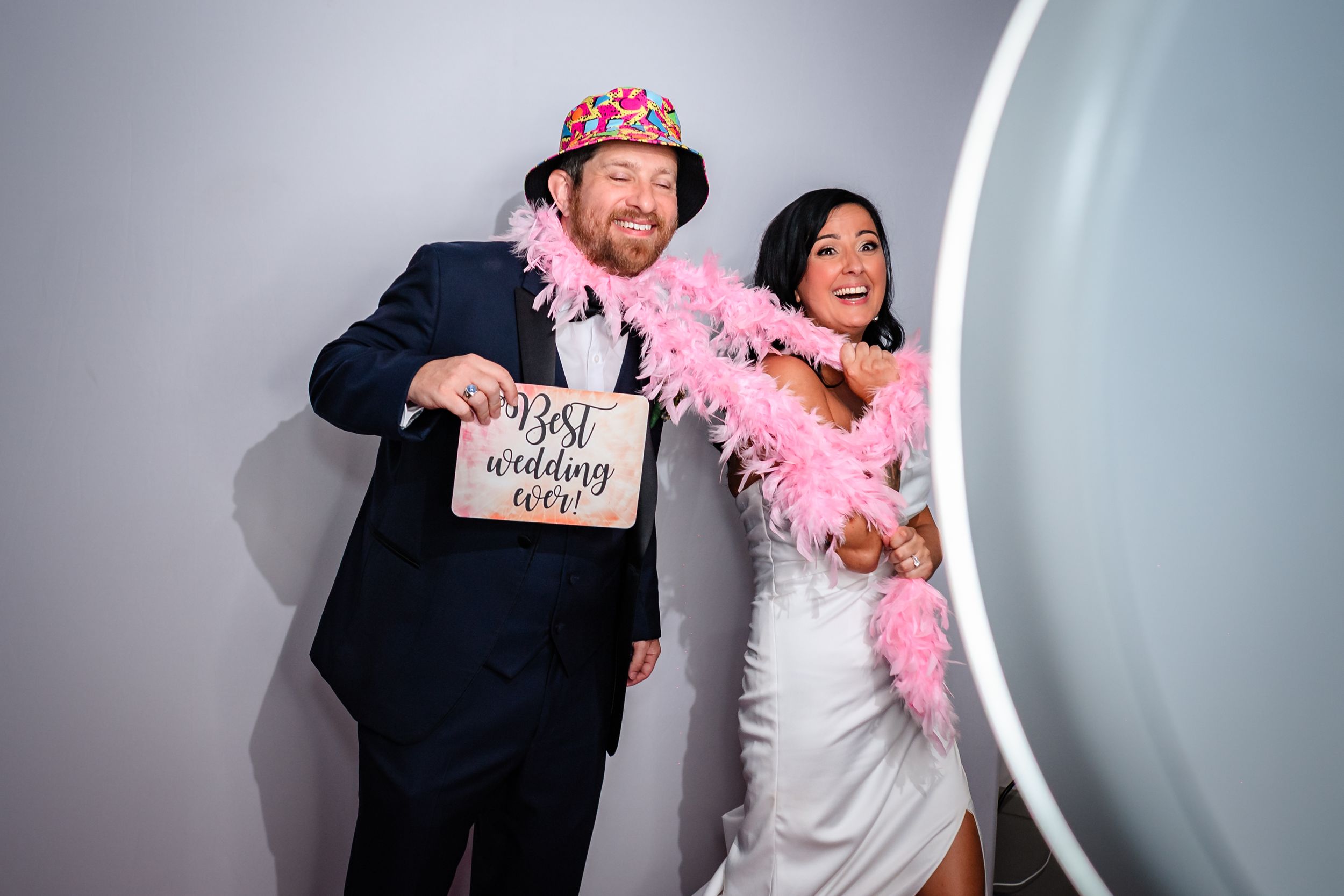 Wedding guests dance and celebrate on the reception dance floor with fun party props and decorations.