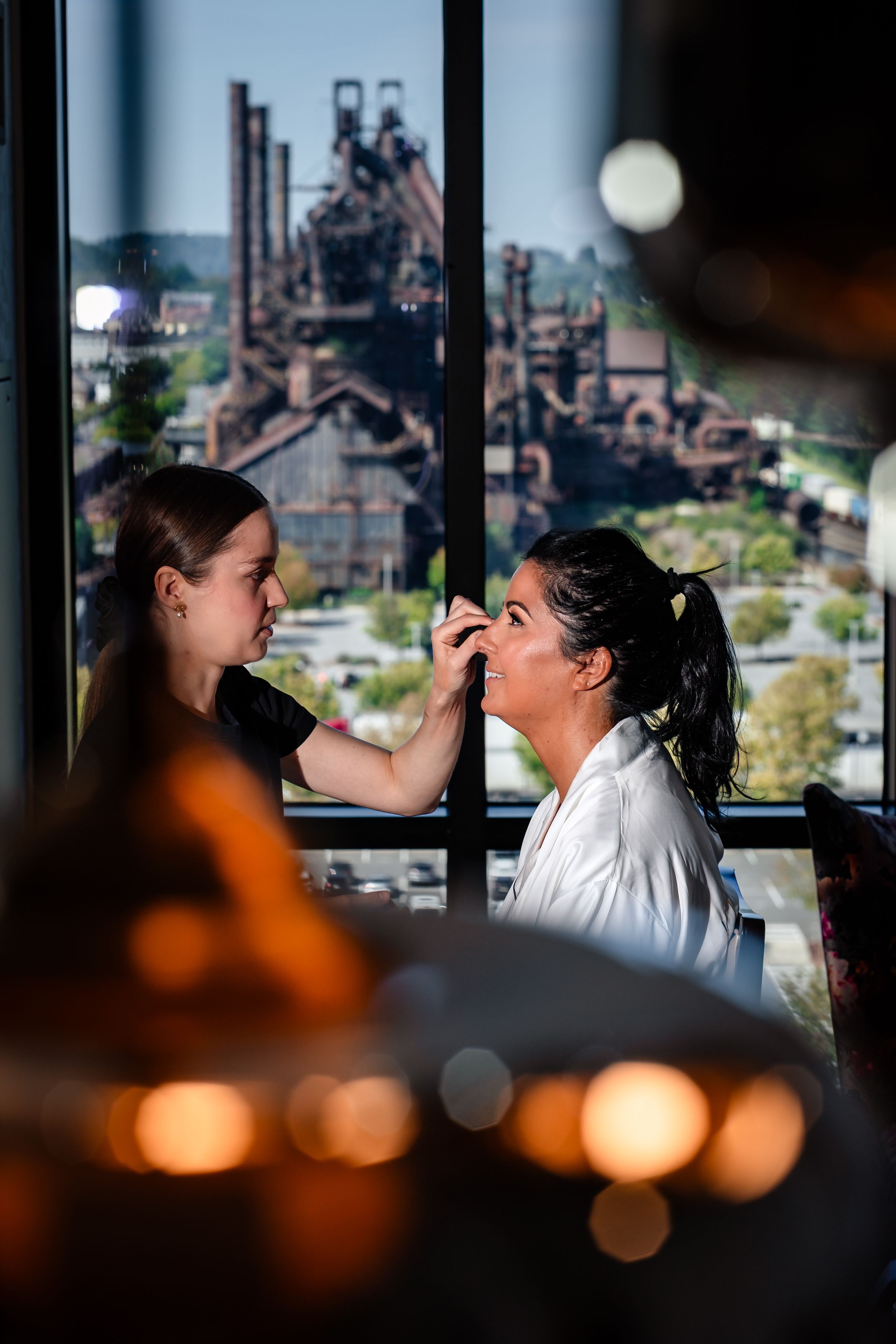 Wedding preparations in a room with large windows overlooking a cityscape.