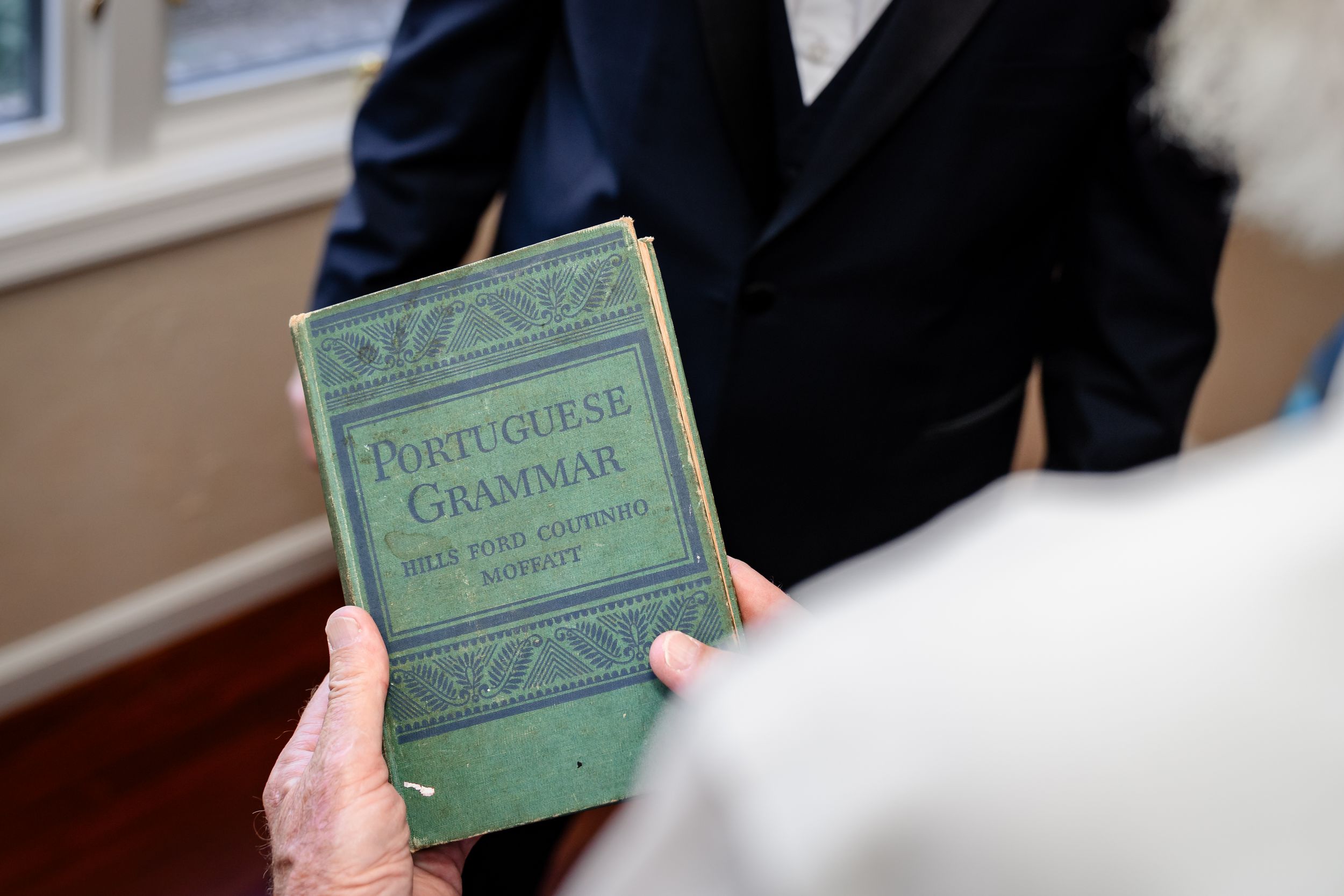 Vintage green book being examined during wedding preparations.