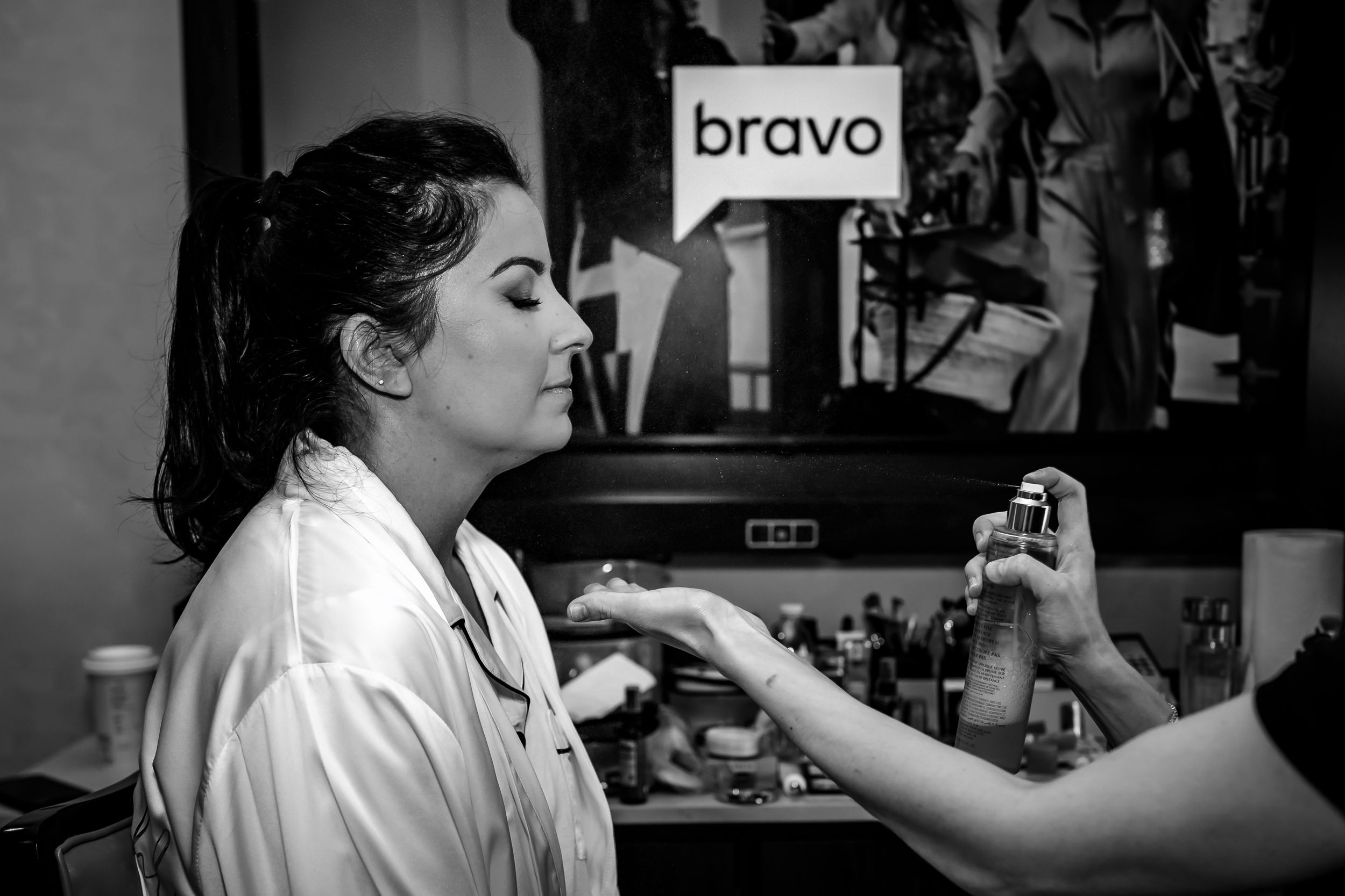 Makeup application in progress during wedding day preparations with professional lighting.
