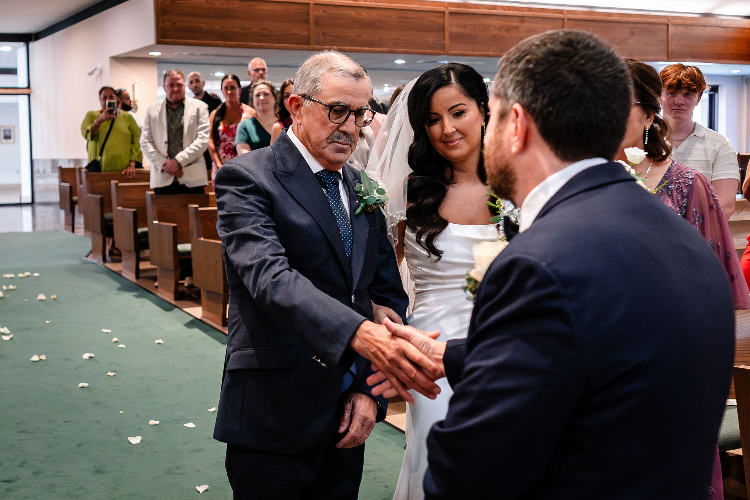 Wedding celebration candid moments captured in a church with brick walls.