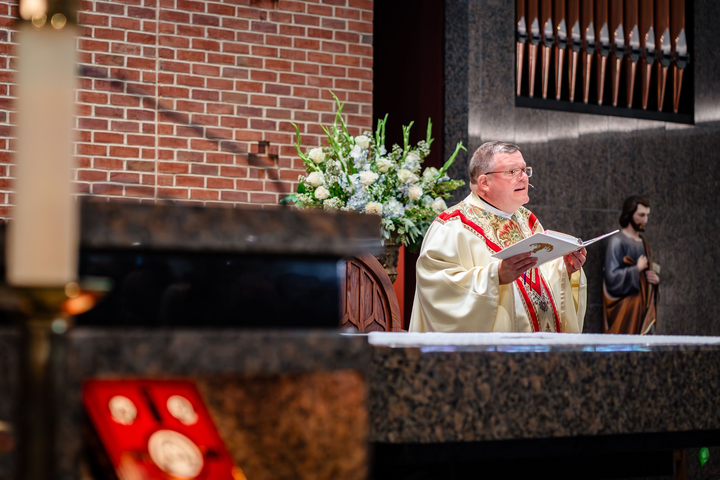 Church altar decorated for wedding ceremony with brick walls and wooden details.