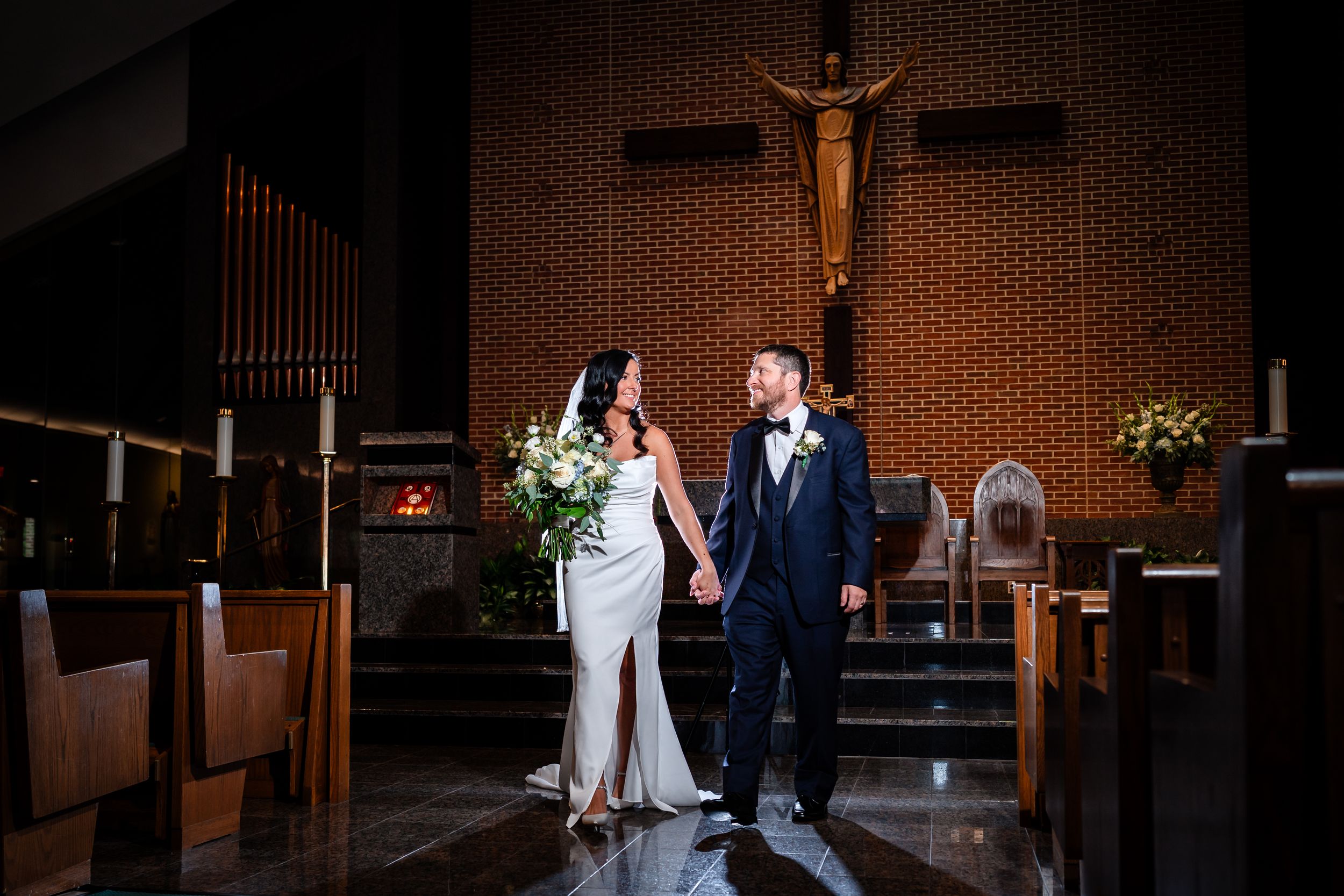 Dramatic church wedding ceremony with artistic lighting and architectural details.