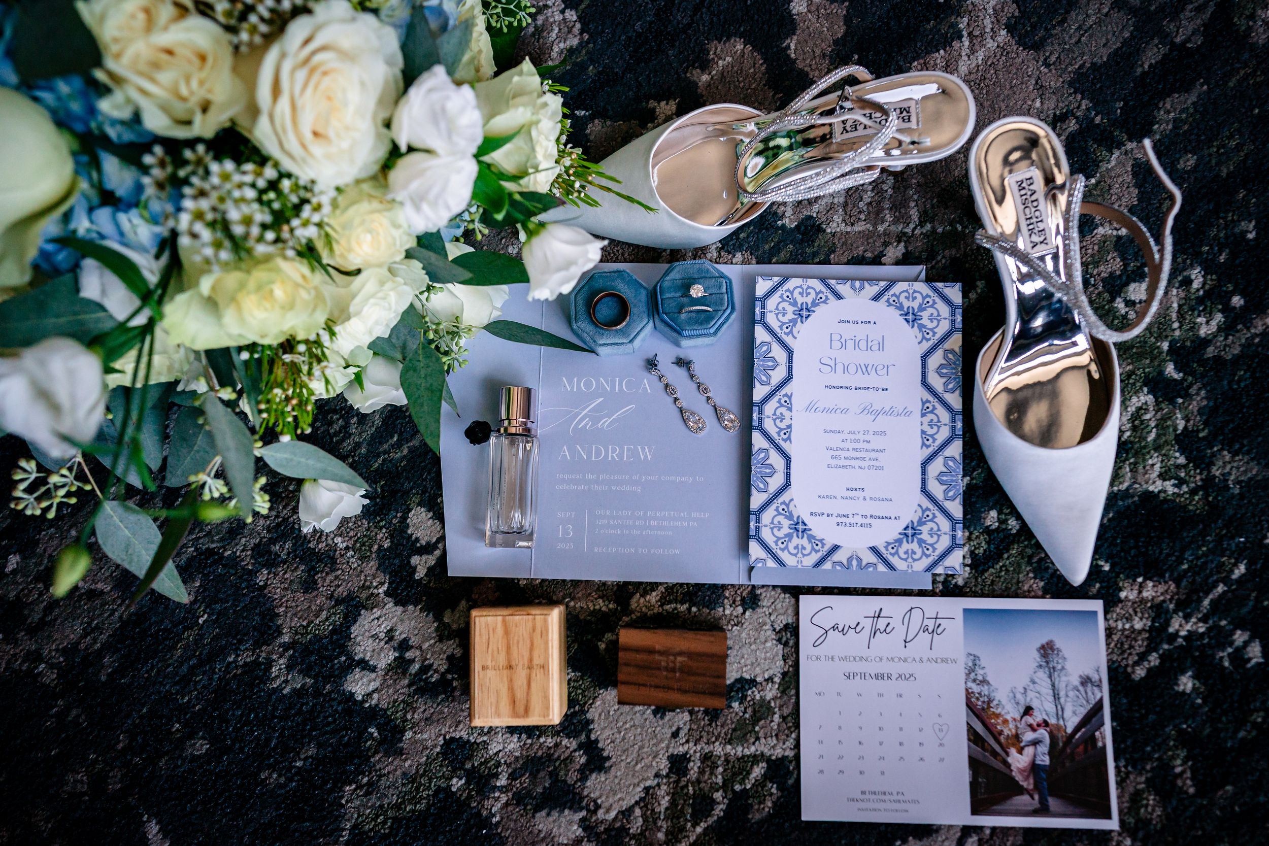 Wedding stationery and white floral arrangements elegantly displayed on dark surface.