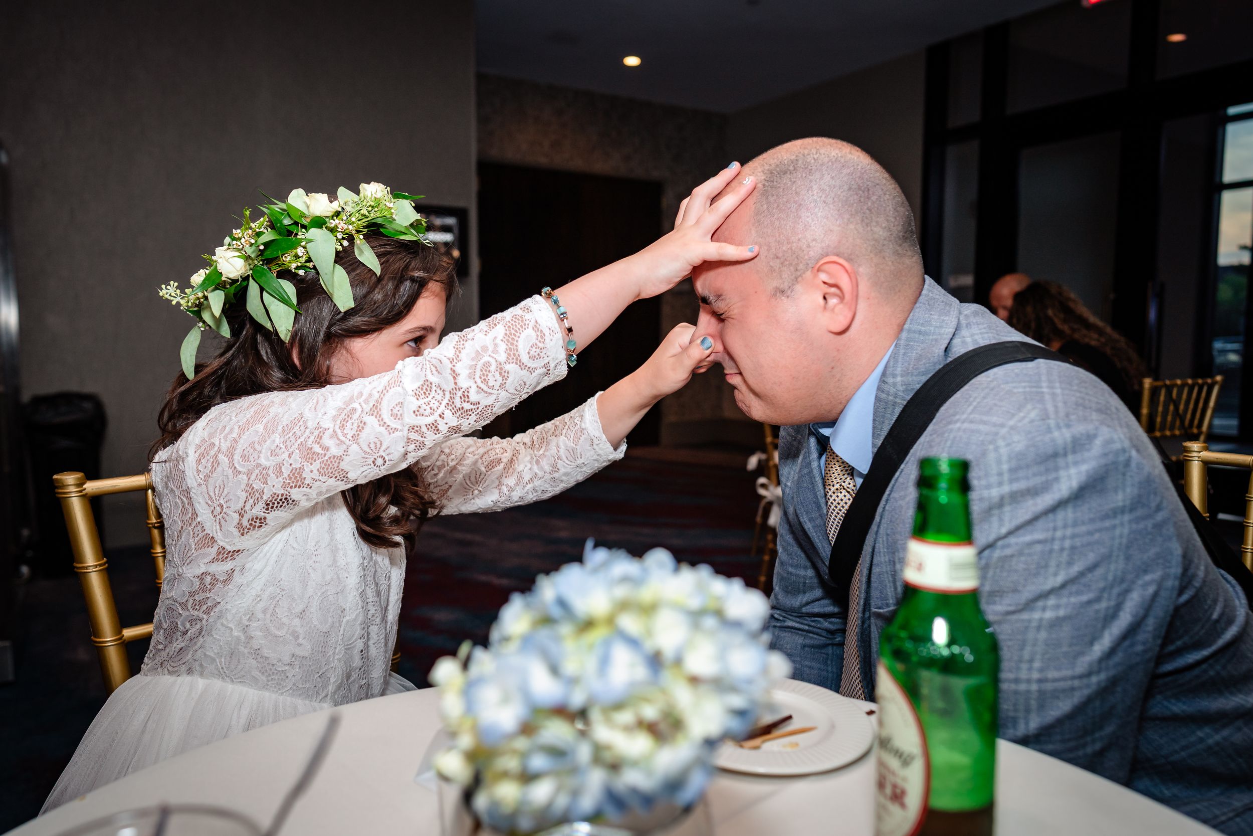 Wedding guests dance and celebrate during a lively reception with festive lighting and decor.