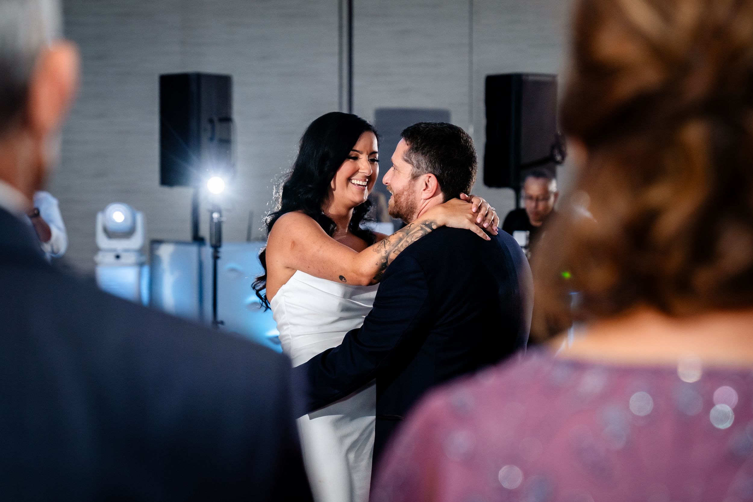 Wedding party members dance enthusiastically during an indoor reception celebration.