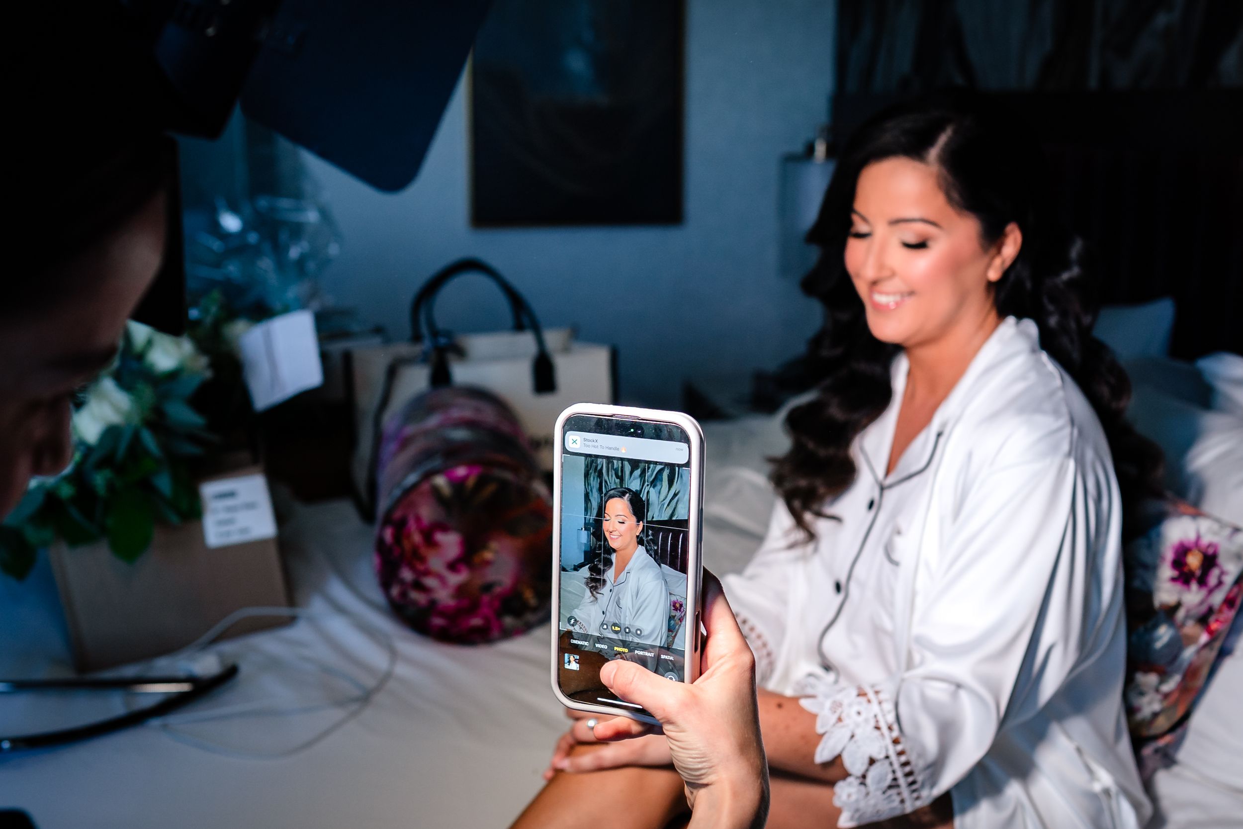 Wedding preparation scene with makeup and phones in dark ambient lighting.