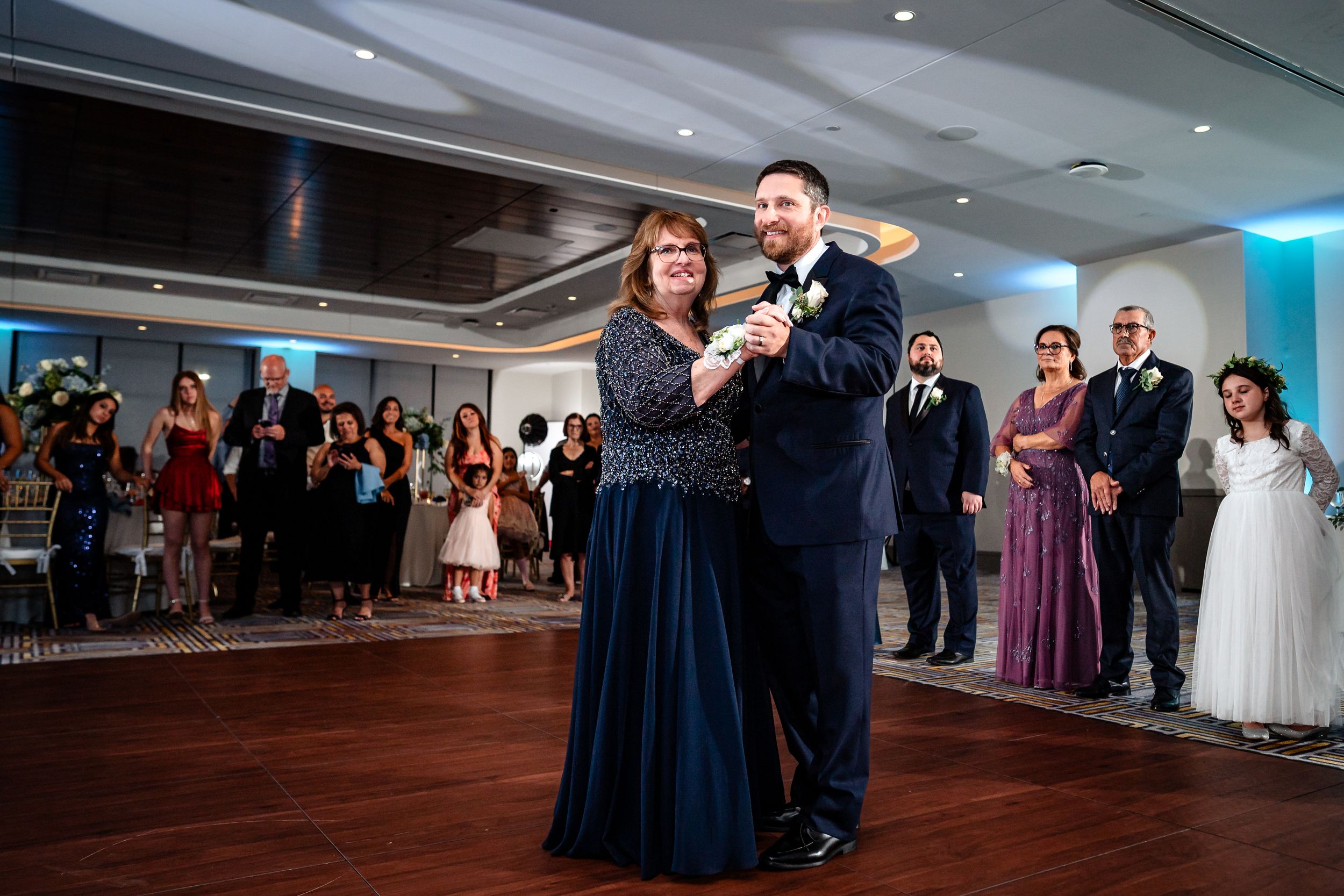 Wide view of wedding reception dance floor showing guests celebrating with the wedding party.