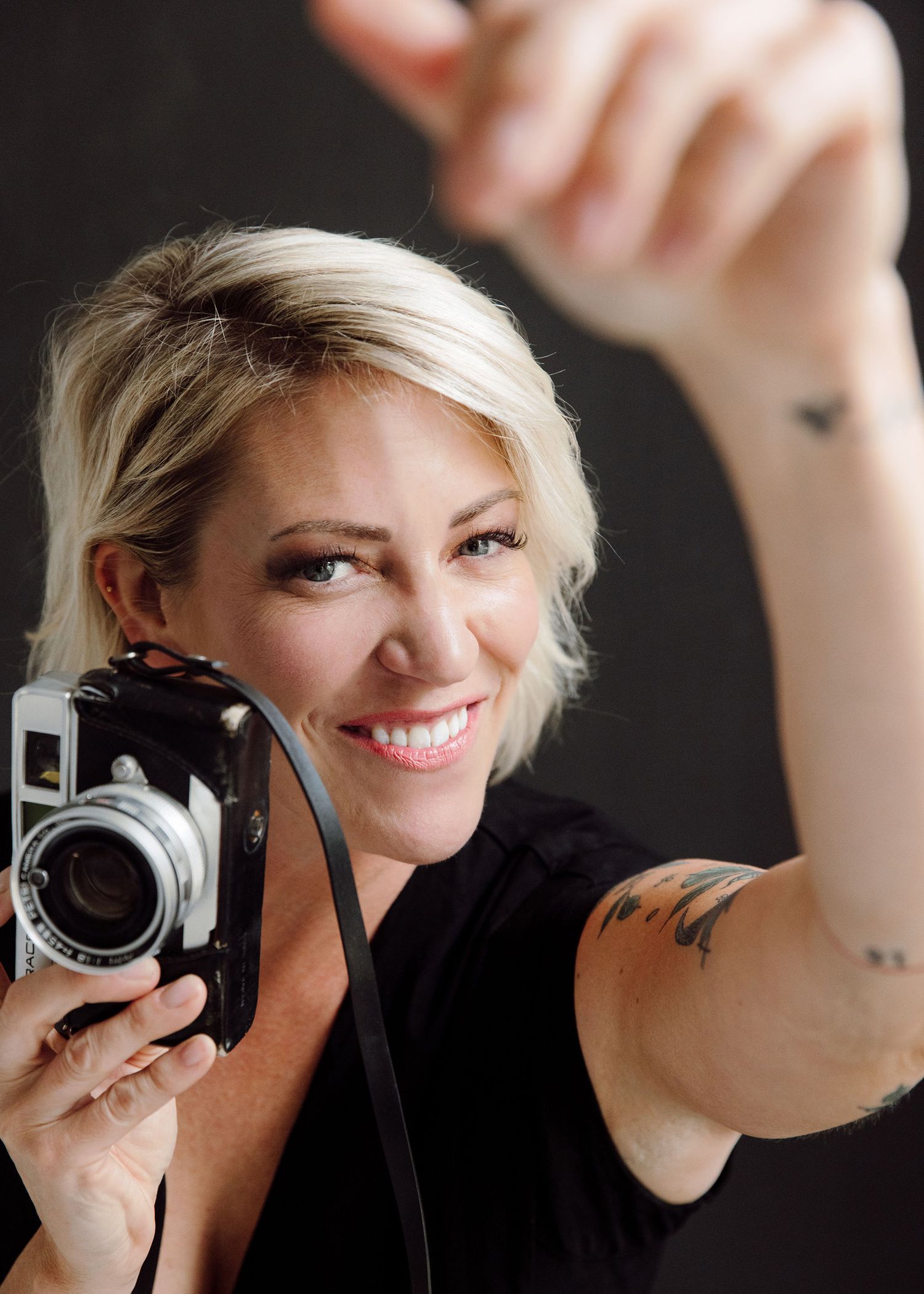 Creative self-portrait series with vintage camera against dark background.