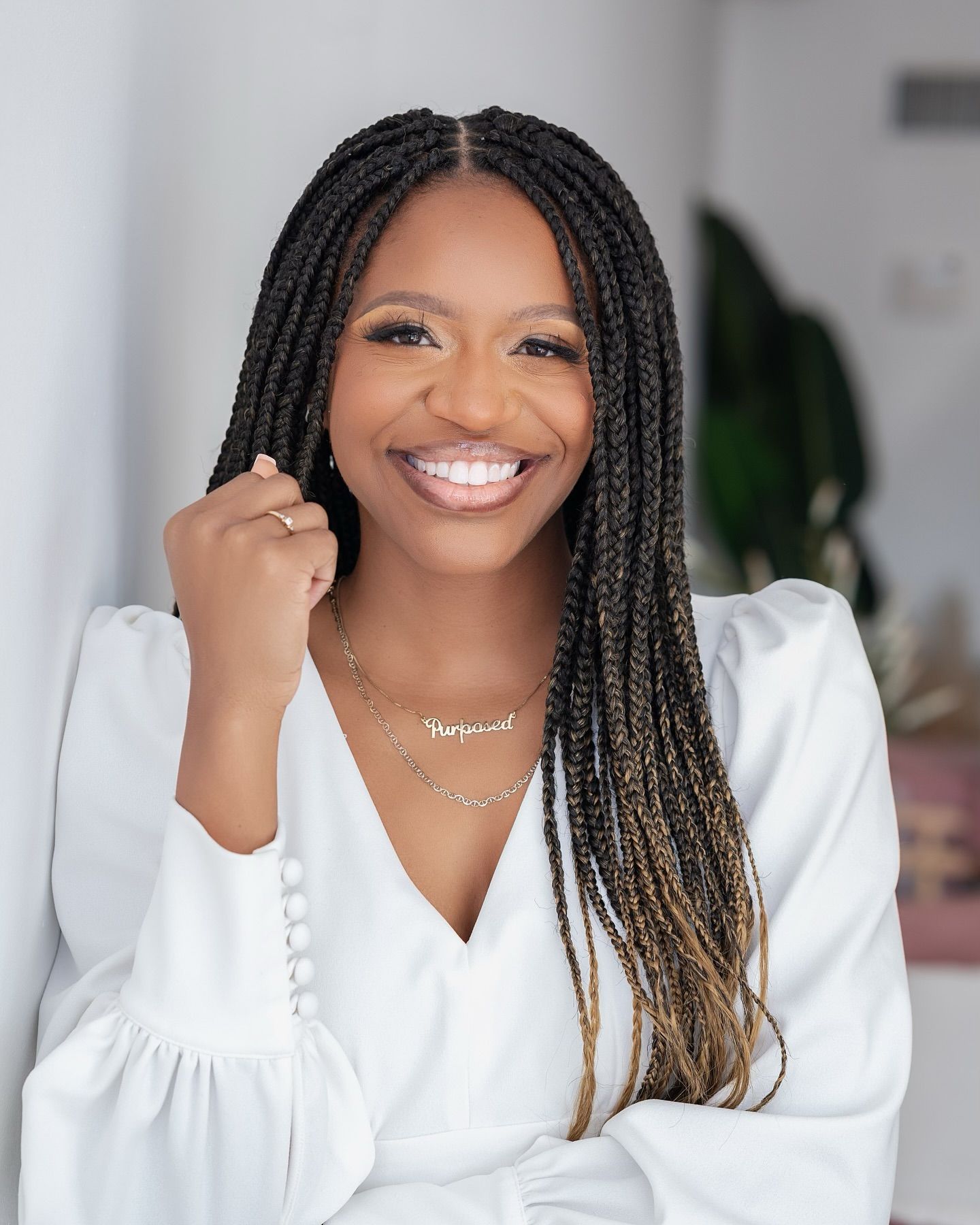 Someone in a white top smiles while placing colorful sticky notes on a white wall during a planning session.