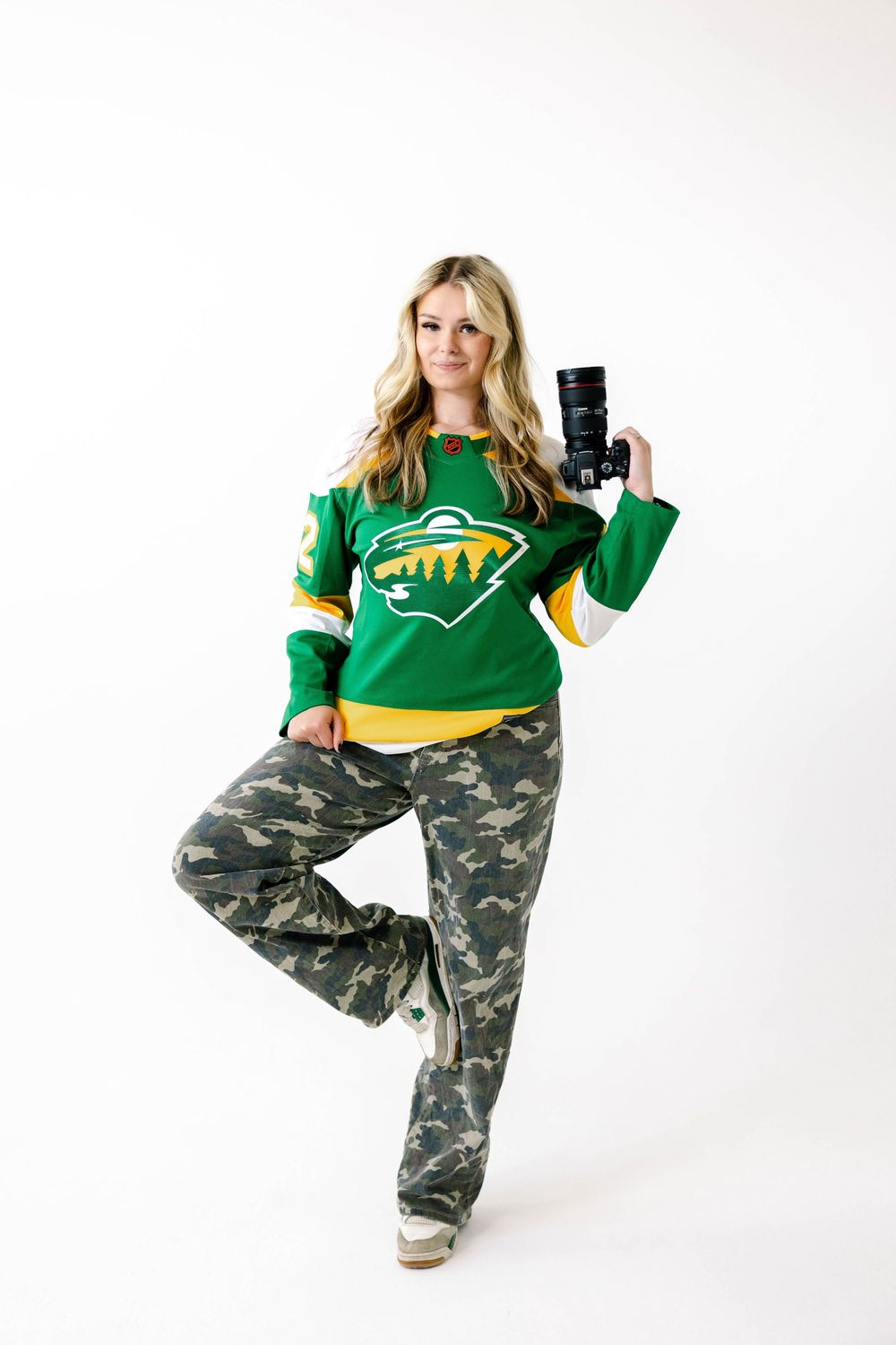 Model in green sports jersey and camouflage pants poses in three different positions against white background.