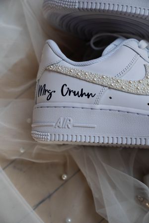Customized white Nike Air Force 1 sneaker with crystal embellishments and personalized text.