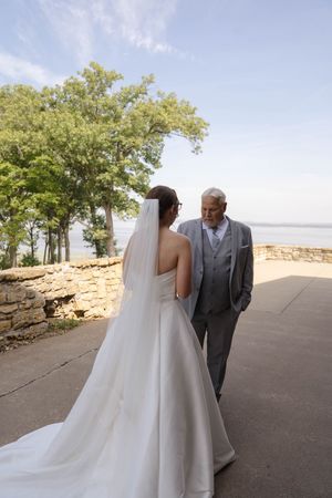 Bride and father share emotional first look against scenic overlook backdrop.